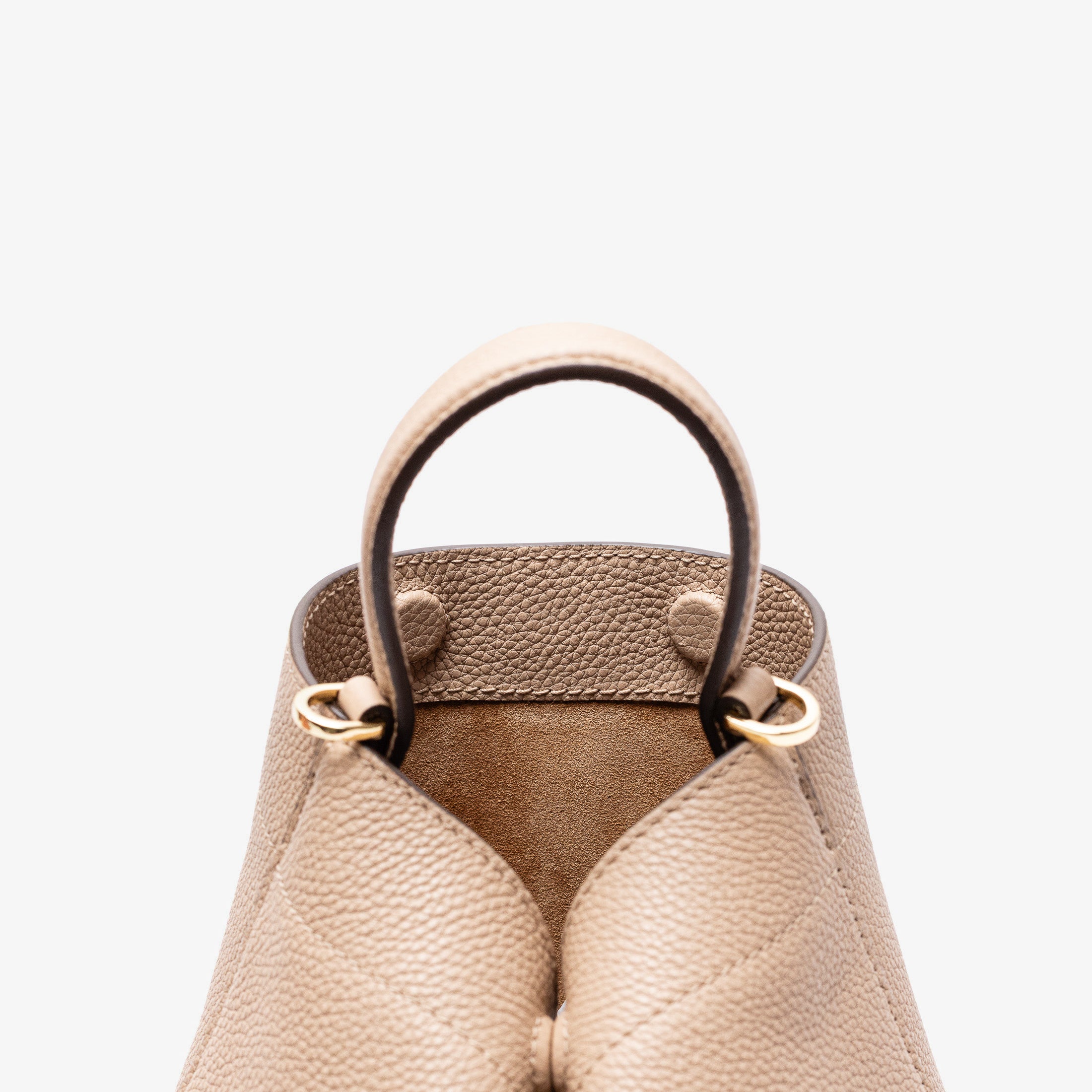 Close up of the top of Stow London's Mini Curve in Camel pebbled leather featuring the hidden magnets, suede interior lining and gold hardware on a light grey background