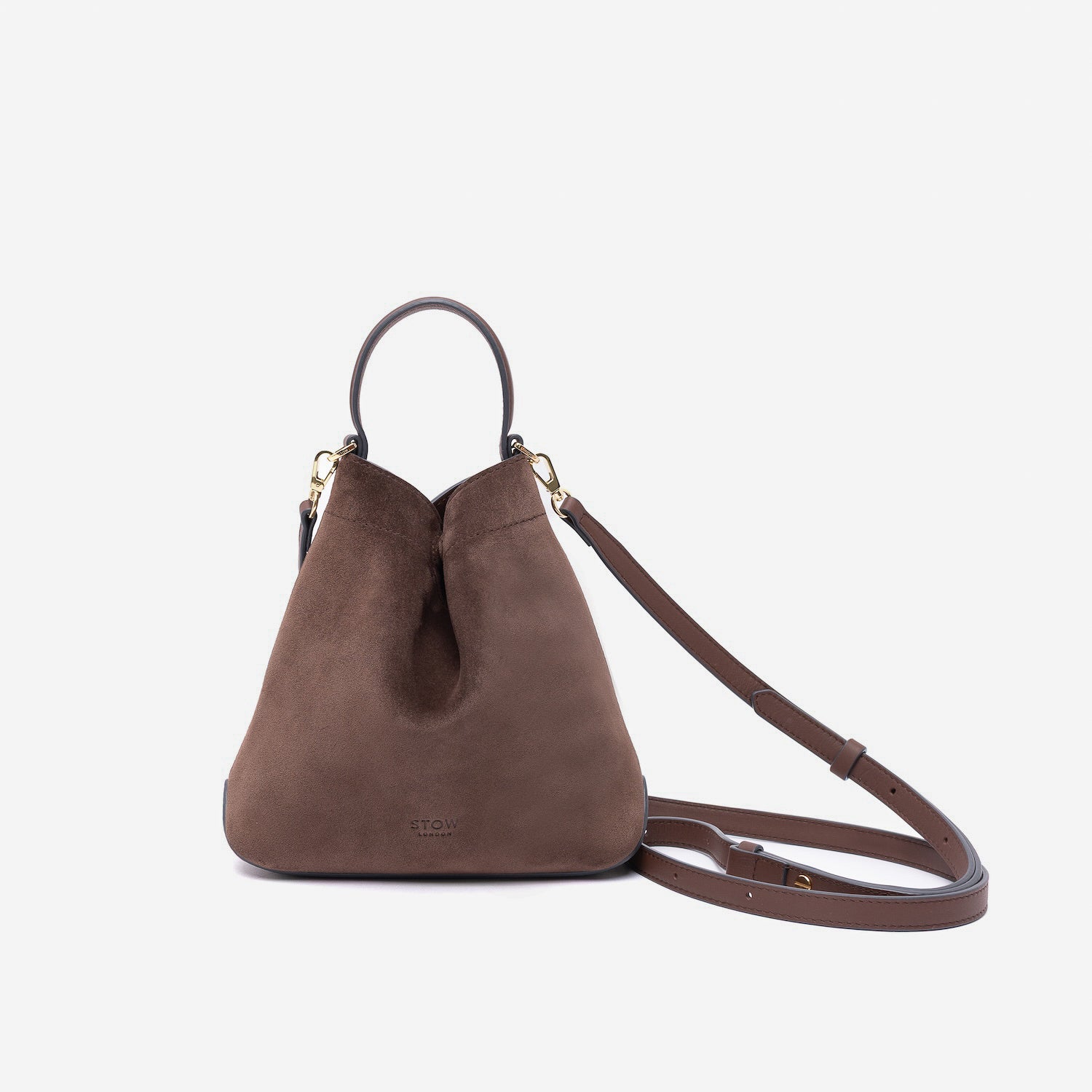 STOW London's Mini Curve in Chocolate suede leather and detachable leather crossbody strap on a light grey background