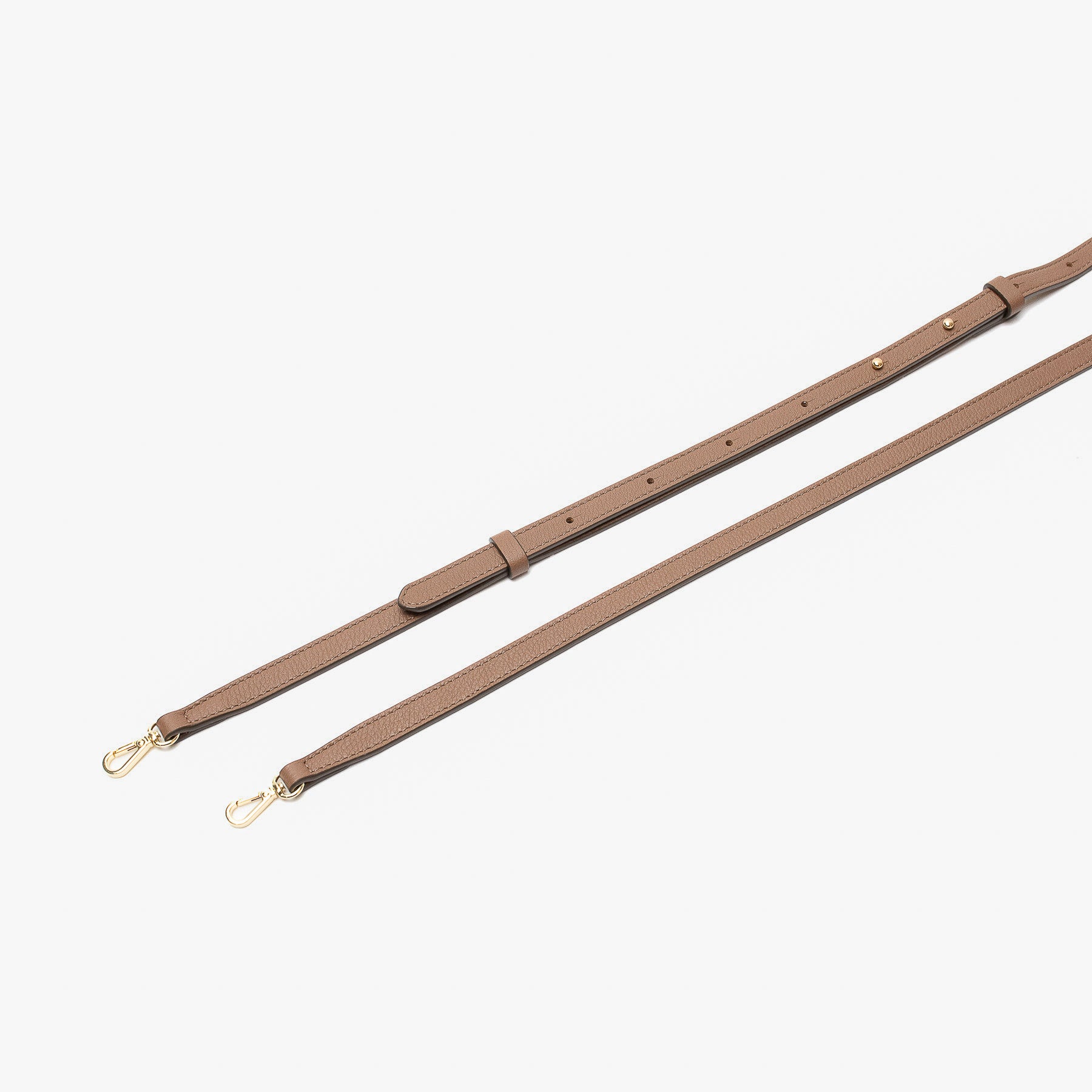 Close up of the detachable leather crossbody strap for STOW London's Mini Curve in Mocha pebbled leather on a light grey background