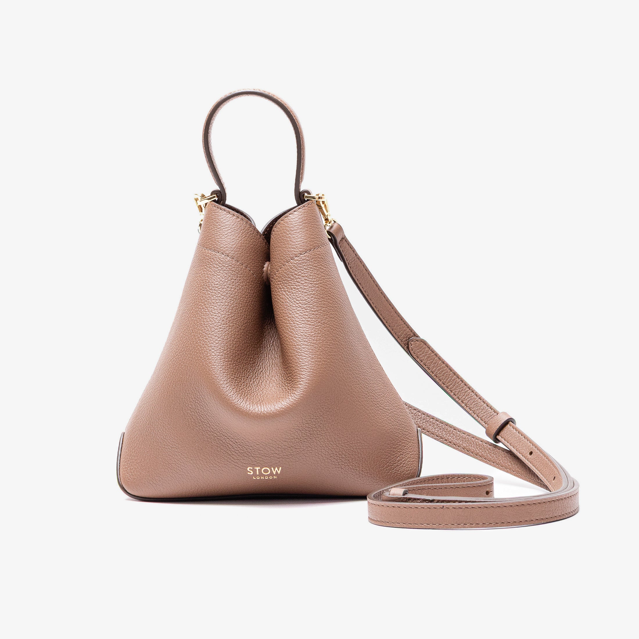 STOW London's Mini Curve in Mocha pebbled leather and detachable leather crossbody strap on a light grey background