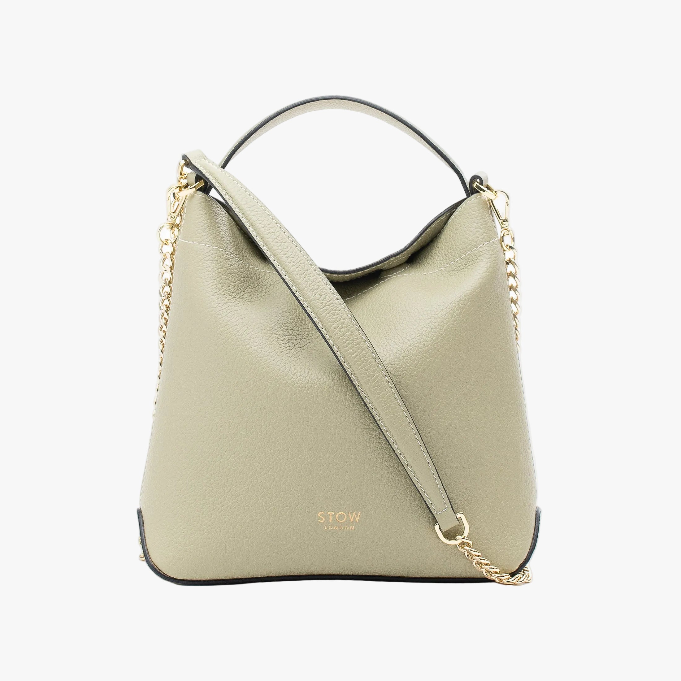 STOW London's Mini Curve in Pale Green pebbled leather and detachable gold chain crossbody strap styled as a flap bag on a light grey background