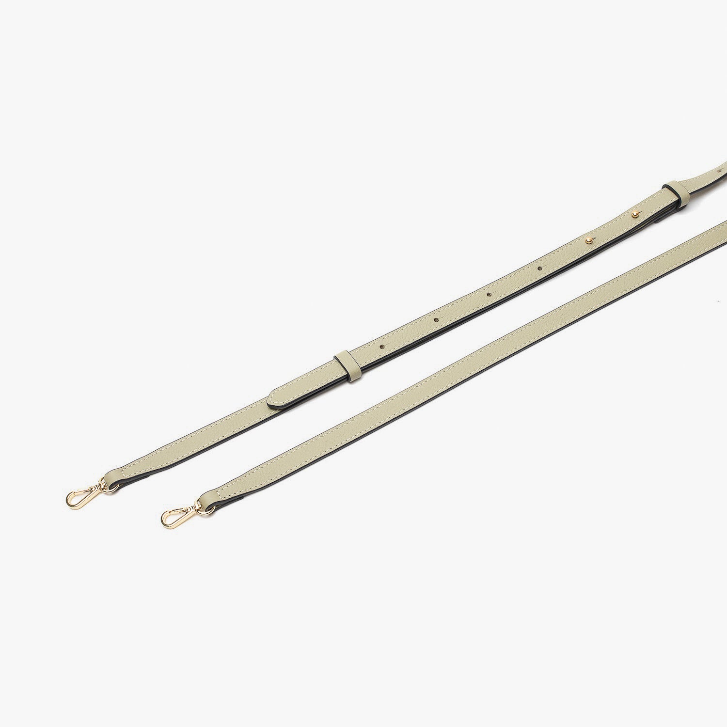 Close up of the detachable leather crossbody strap for STOW London's Mini Curve in Pale Green pebbled leather on a light grey background