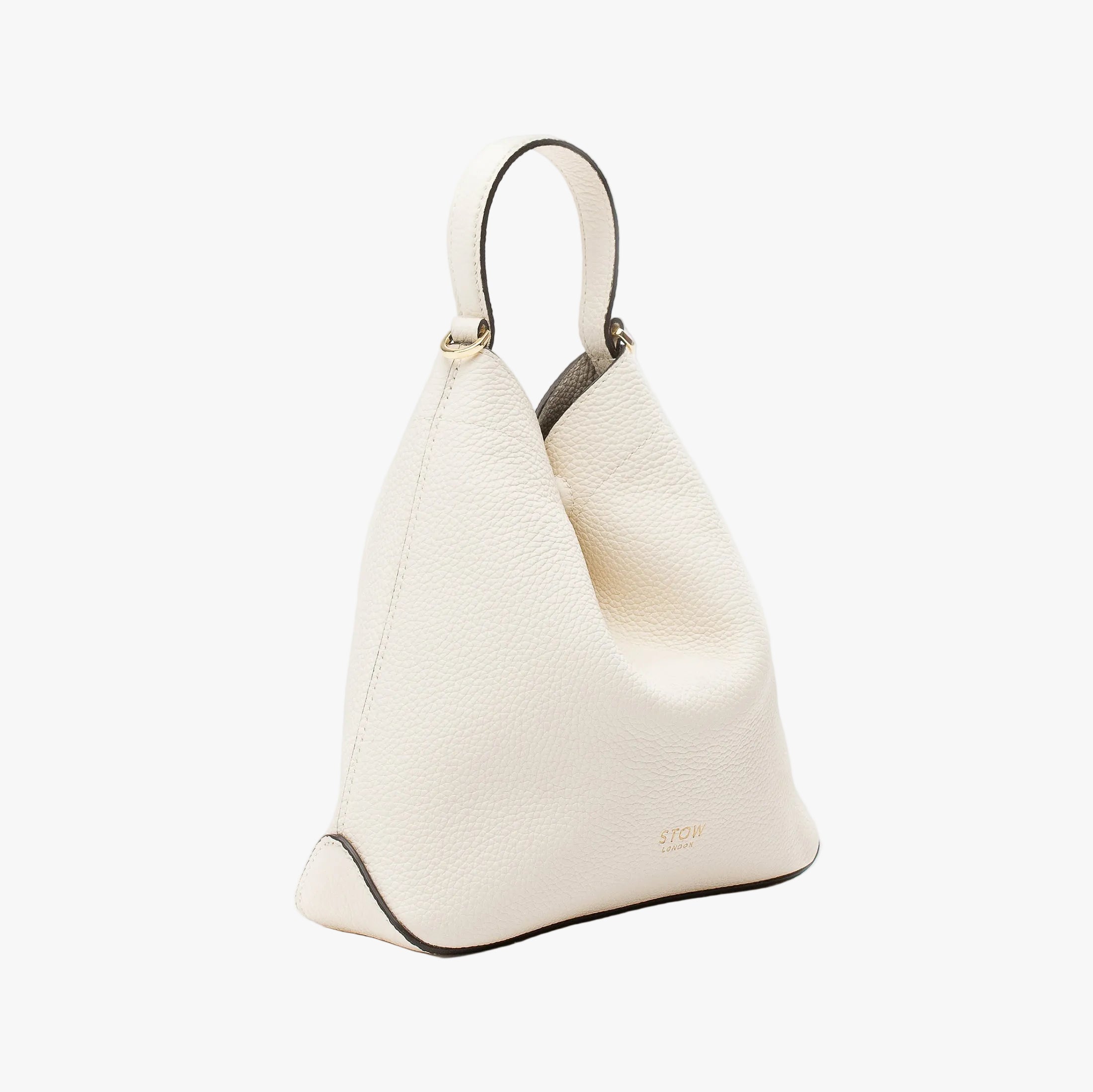 Off-axis view of STOW London's Mini Curve in Spring Moon pebbled leather on a light grey background