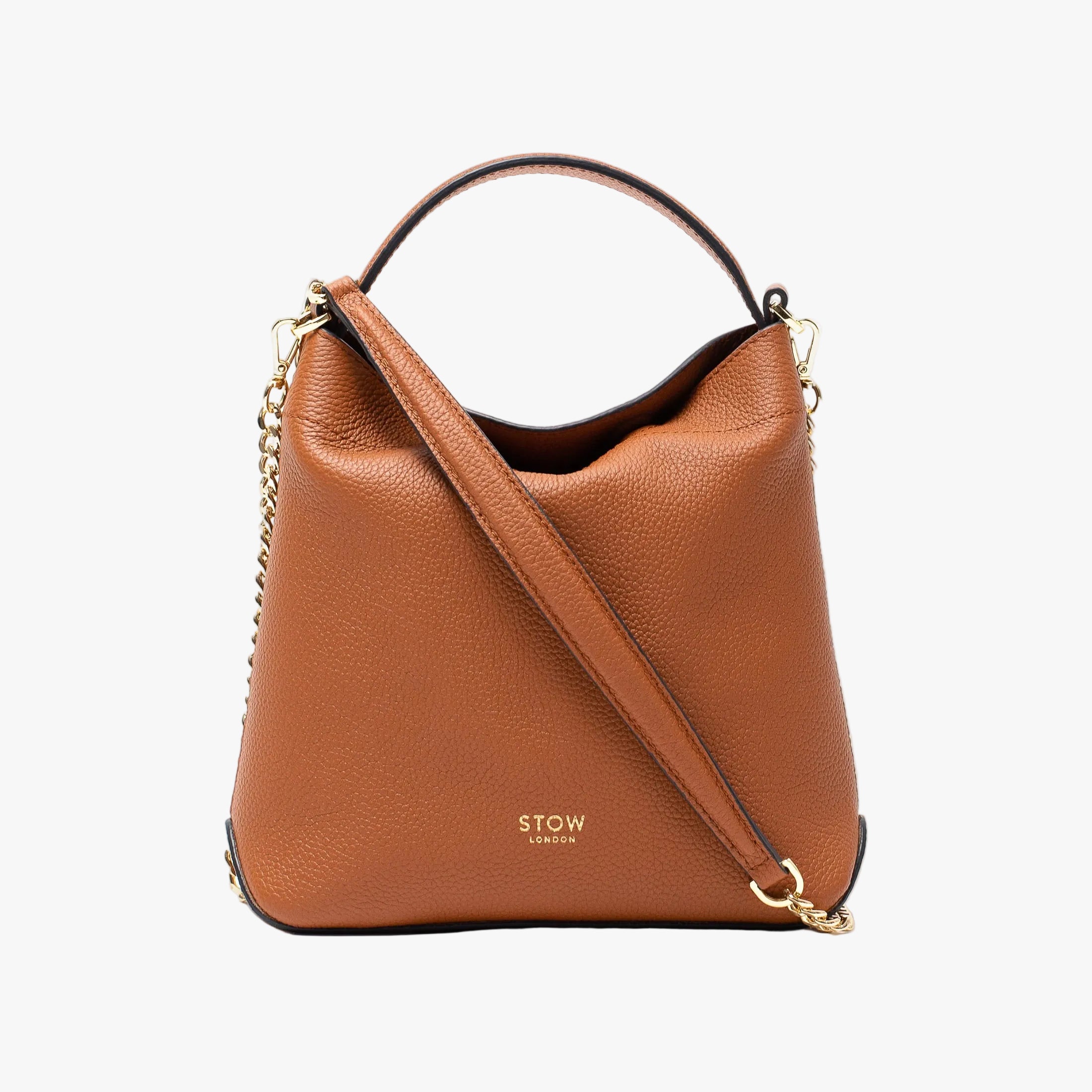 Stow London's Mini Curve in Earth tan pebbled leather and detachable gold chain crossbody strap styled as a flap bag on a light grey background