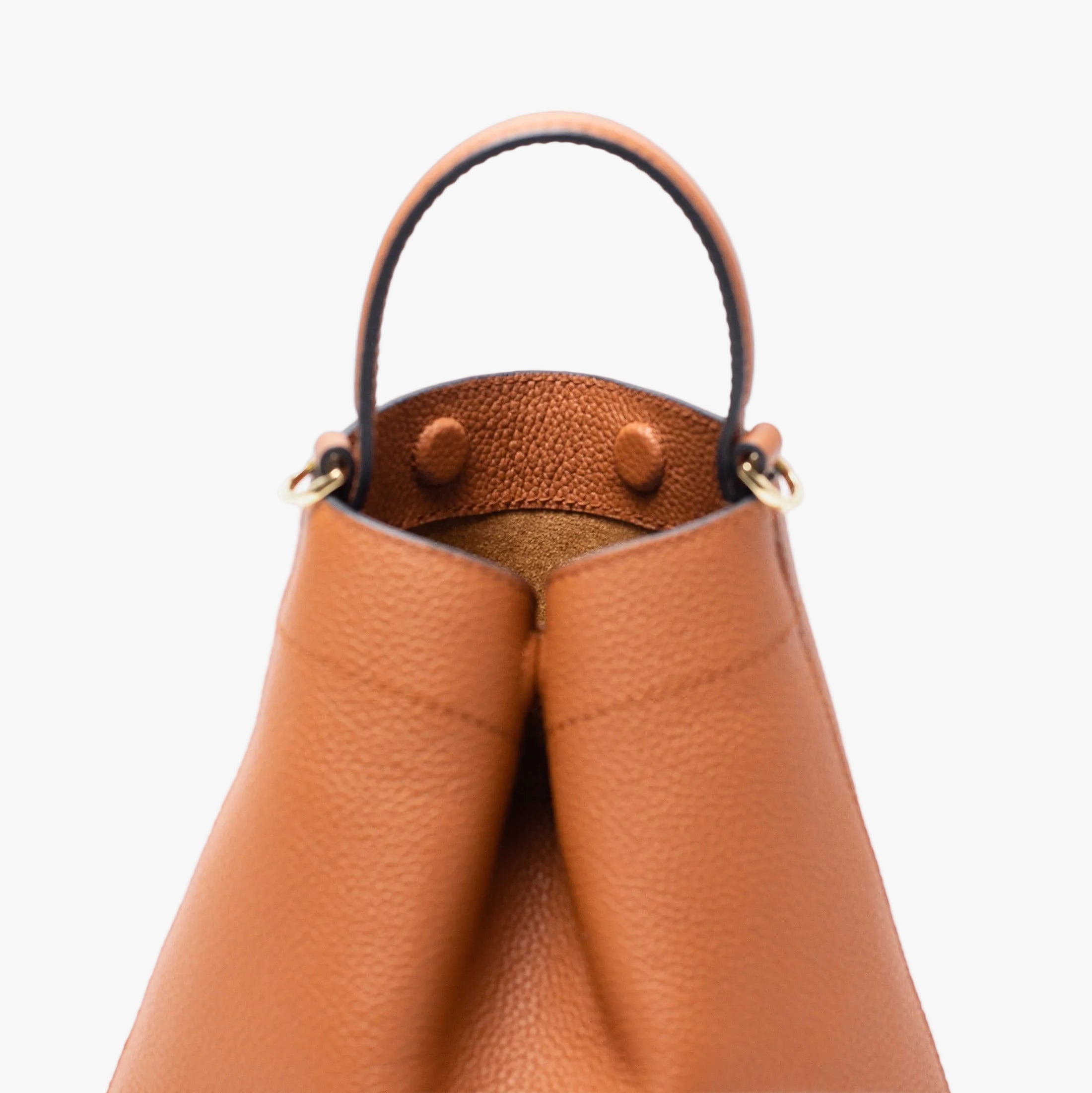 Close up of Stow London's Mini Curve in Earth tan pebbled leather featuring hidden magnets, suede lining and gold hardware on a light grey background