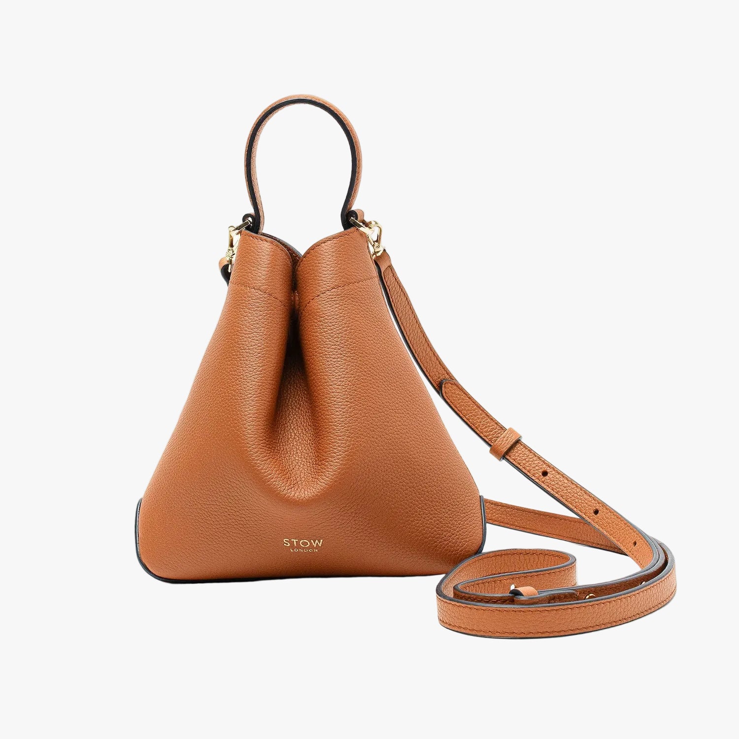 STOW London's Mini Curve in Earth Tan pebbled leather and detachable leather crossbody strap on a light grey background