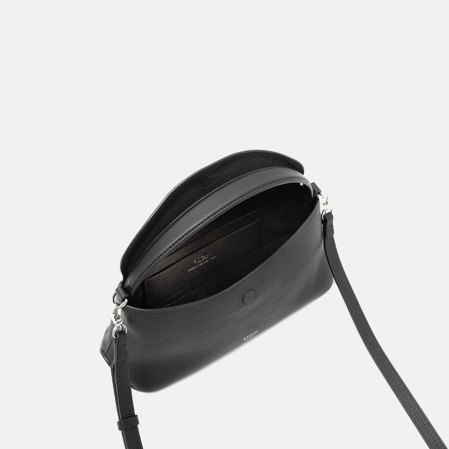 STOW London's Mini East West in Black pebbled leather with flap open showing suede interior and slip pocket featuring silver stainless steel hardware on a light grey background