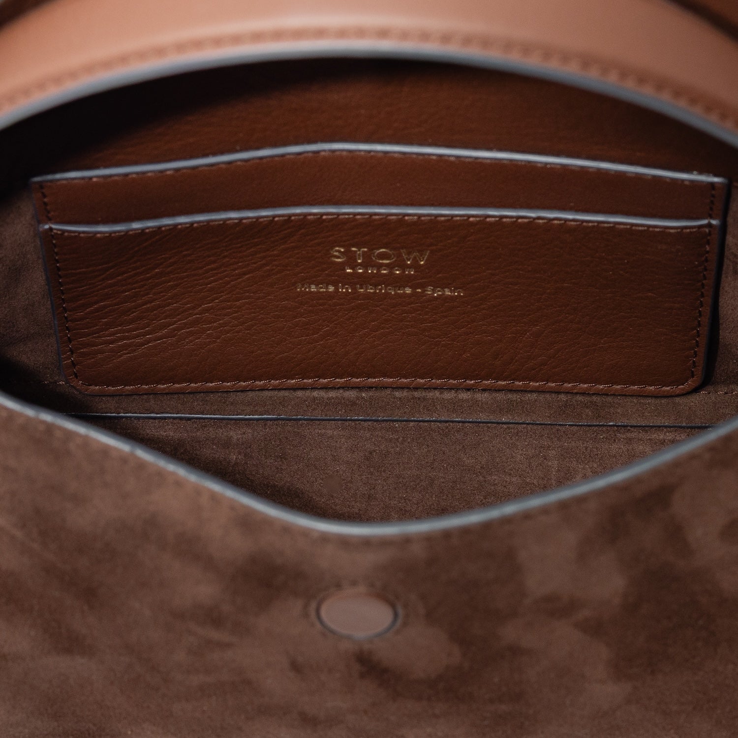 Interior view of STOW London's Mini East West bag in Chocolate Suede leather showing the interior card holder pocket featuring gold details