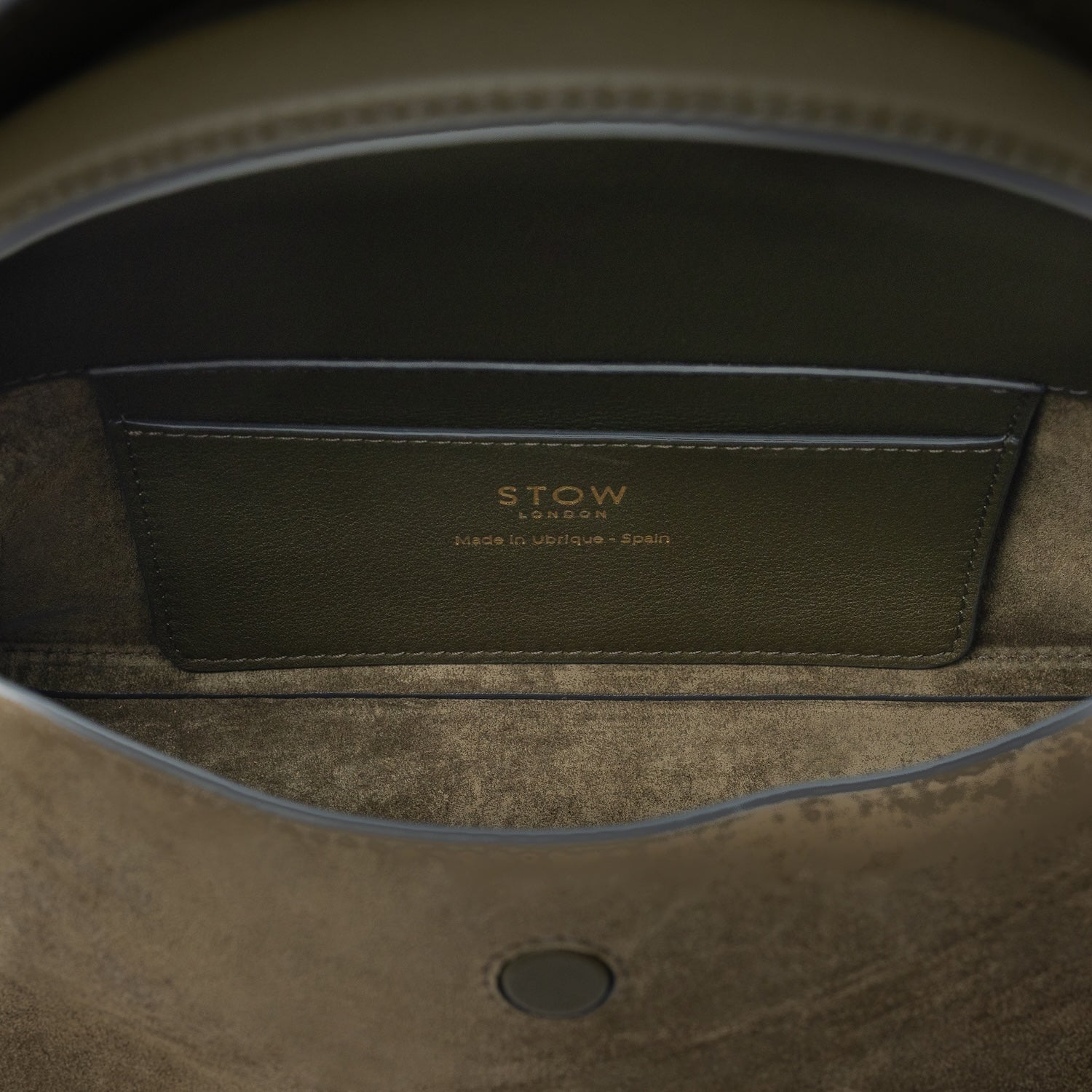 Interior view of STOW London's Mini East West bag in Dark Green Suede leather showing the interior card holder pocket featuring gold details