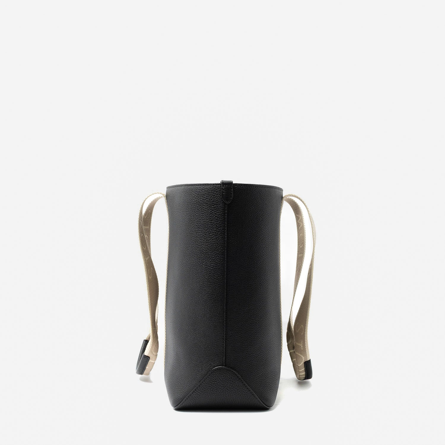 Side view of STOW London's Nastro Tote bag in Black pebbled leather on a light grey background