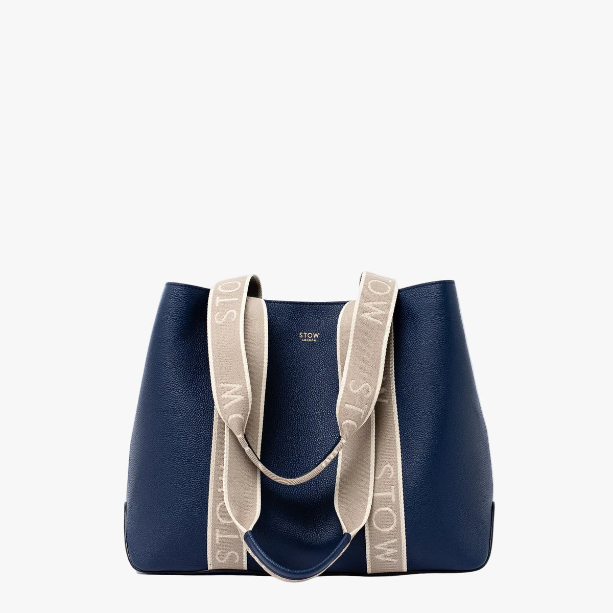 STOW London's Nastro Tote bag in Navy pebbled leather with beige nastro handles featuring 'STOW' branding on a light grey background