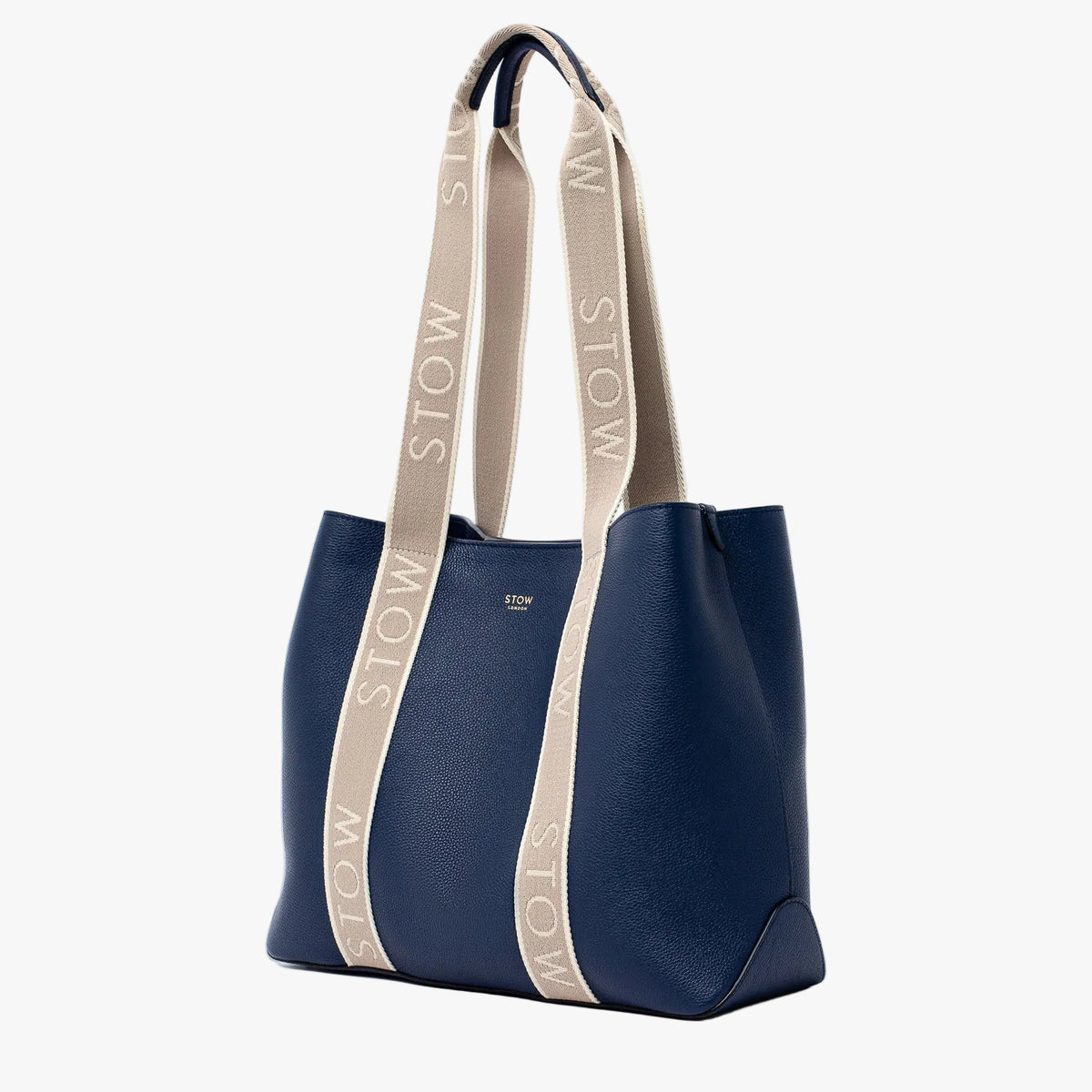 STOW London's Nastro Tote bag in Navy pebbled leather with beige nastro handles featuring 'STOW' branding on a light grey background