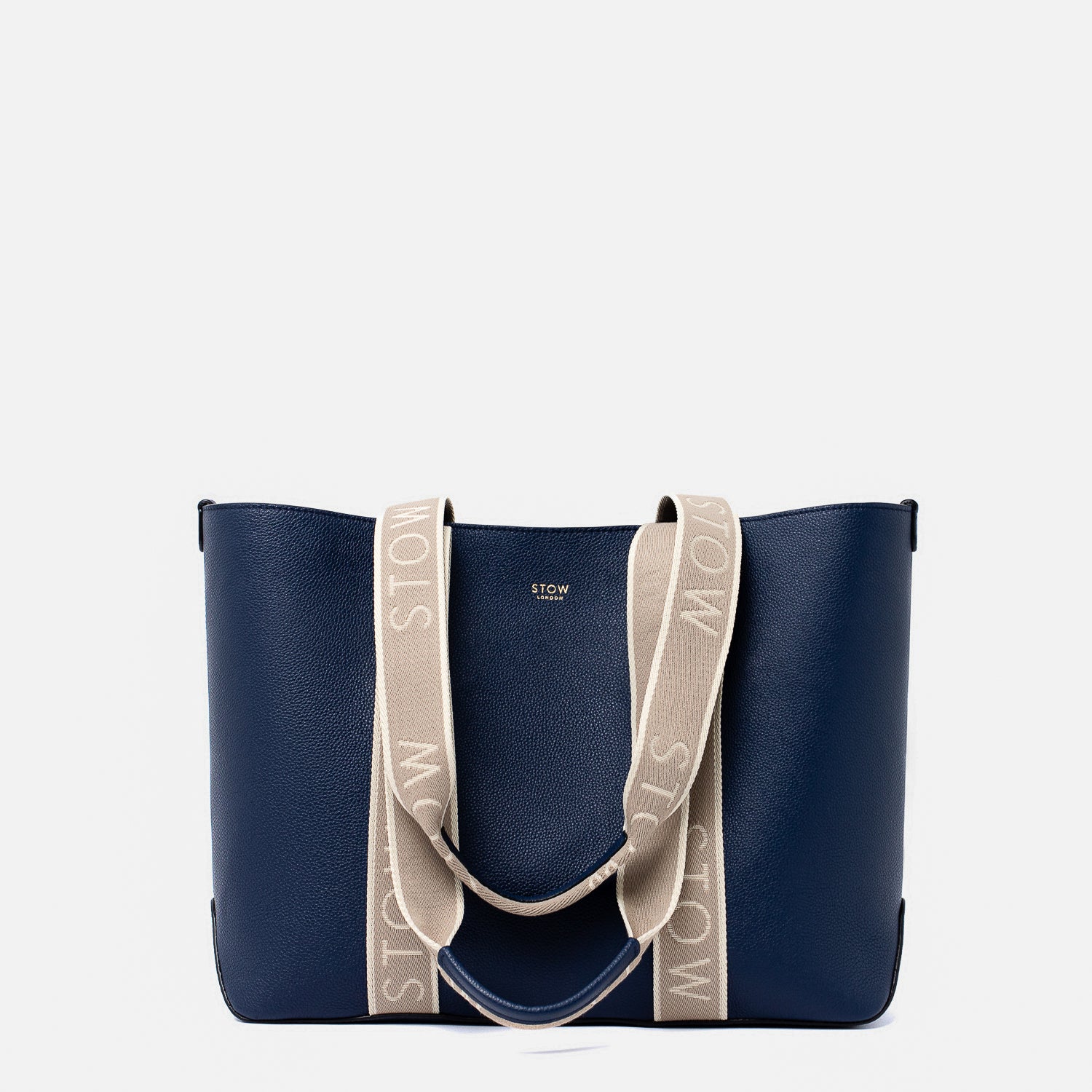 STOW London's Nastro Tote bag in Navy pebbled leather with beige nastro handles featuring 'STOW' branding on a light grey background