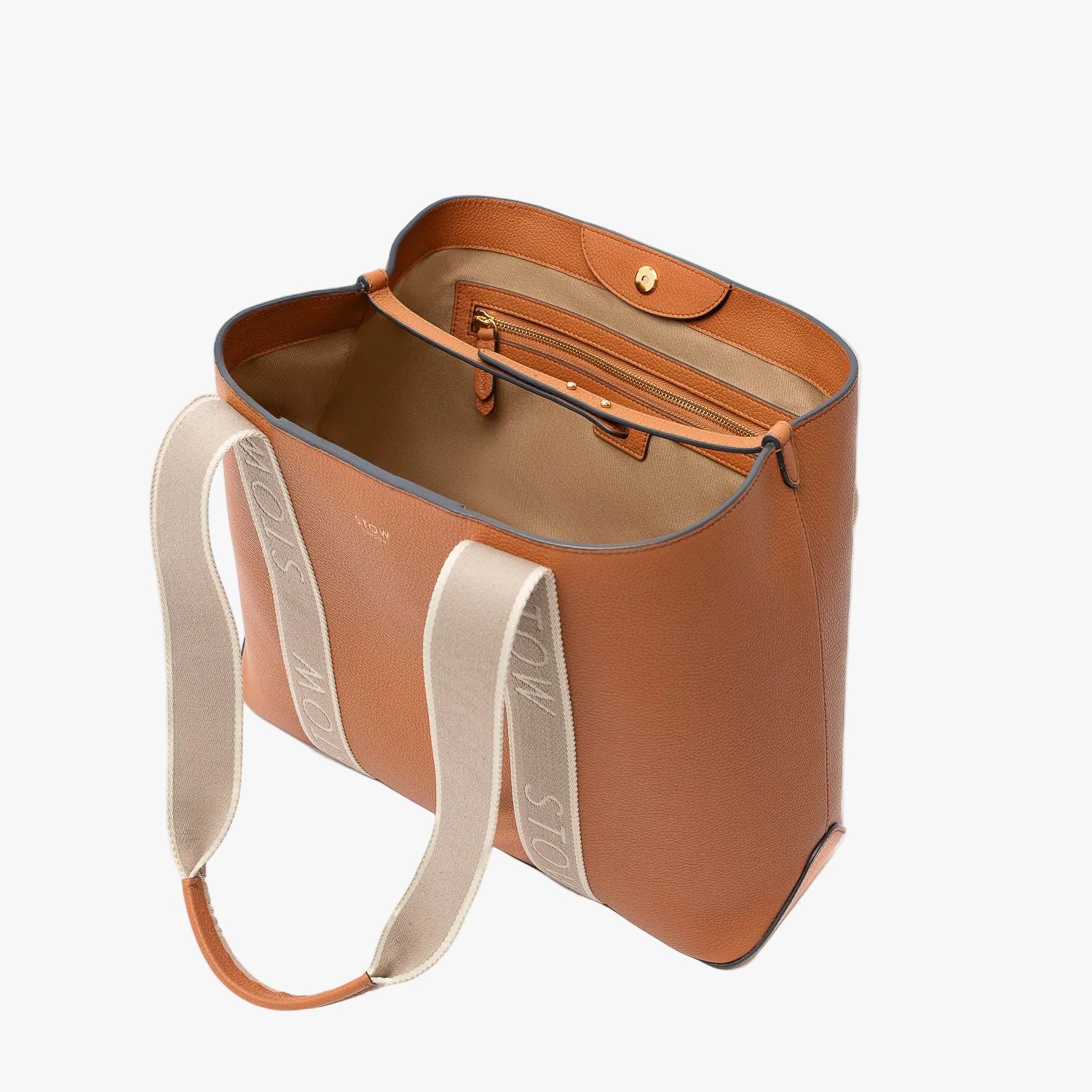 STOW London's Nastro Tote bag in Earth Tan pebbled leather with magnets open showing light beige cotton interior and zip pocket on a light grey background
