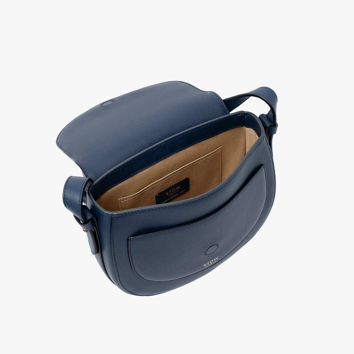 STOW London's Saddle bag in Navy smooth leather with flap open showing light beige interior and slip pocket on a light grey background
