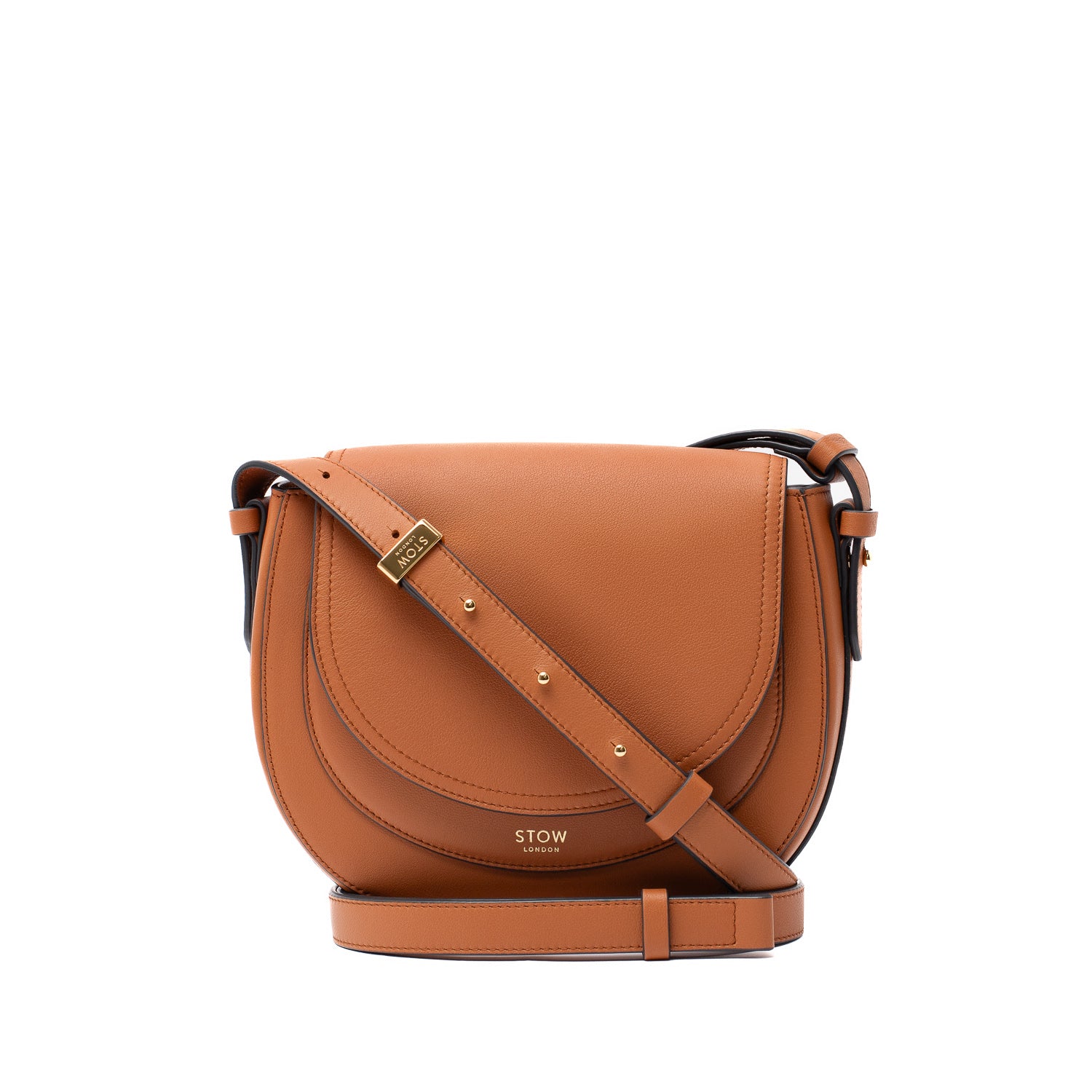 STOW London's Saddle bag in Earth Tan smooth leather with detachable crossbody strap attached featuring gold-coated stainless steel hardware on a white background