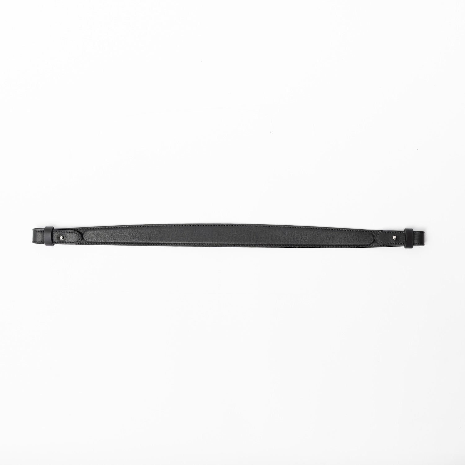 Detachable shoulder strap for STOW London's Curve, Midi Curve and East West in Black smooth leather on a light grey background featuring silver hardware