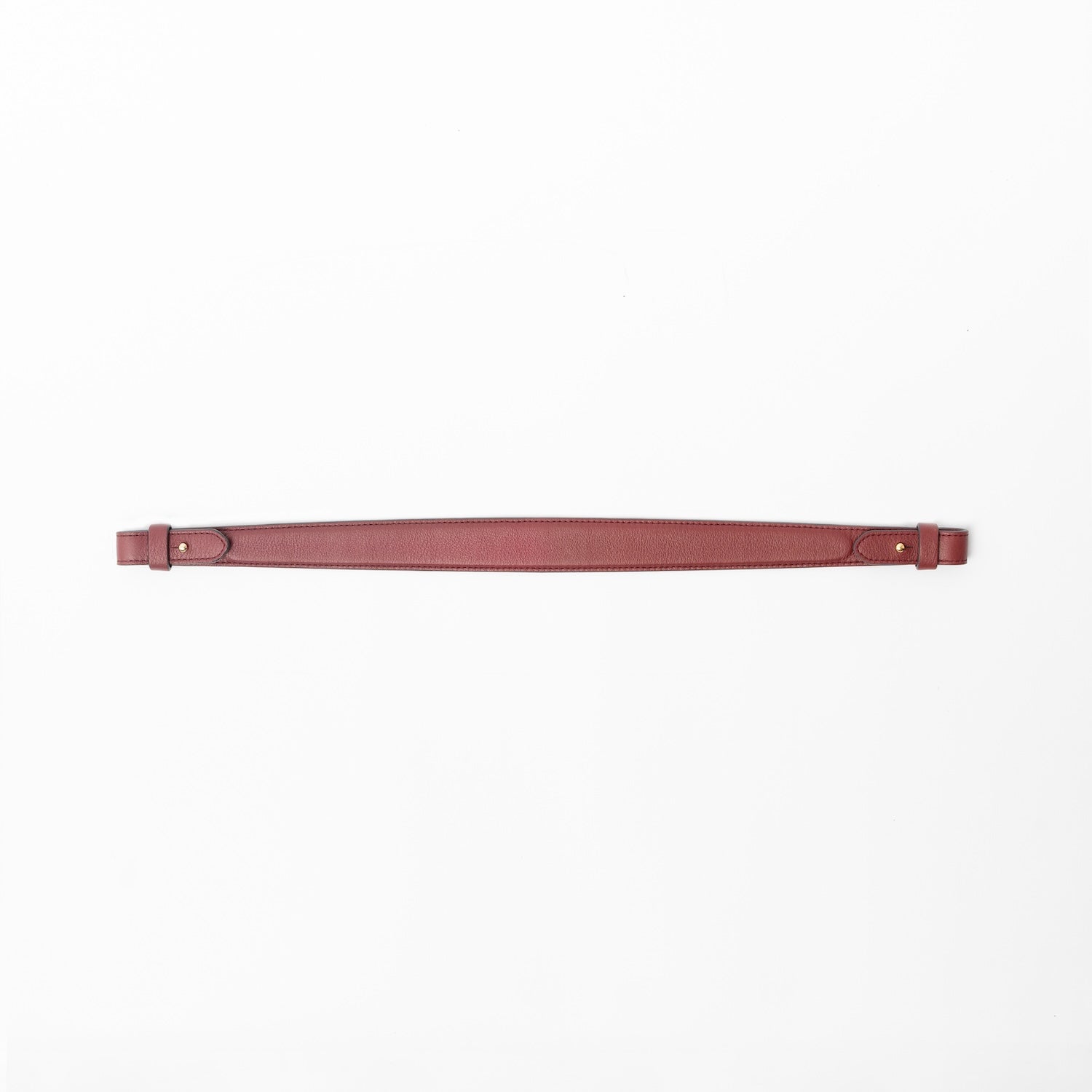 Detachable shoulder strap for STOW London's Curve, Midi Curve and East West in Burgundy smooth leather on a light grey background featuring gold hardware