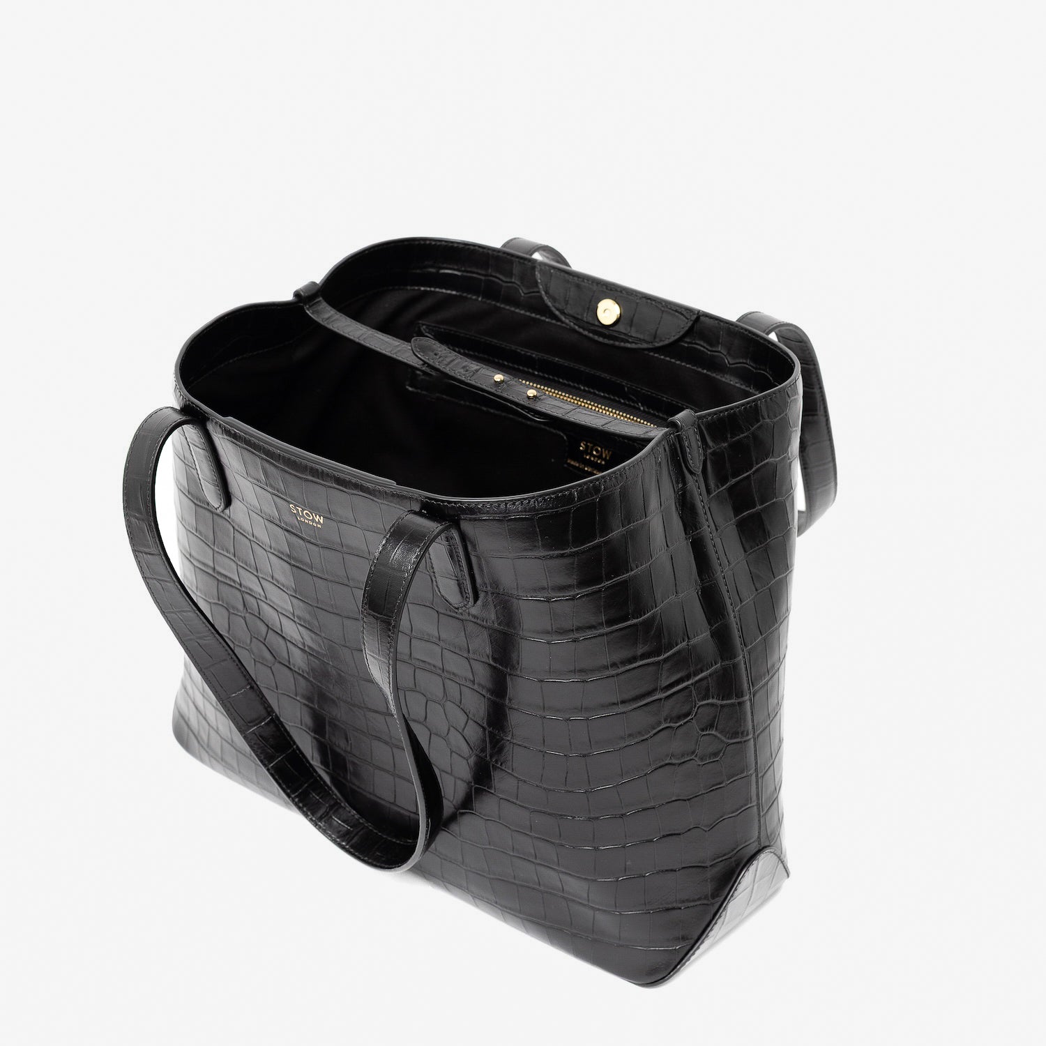 Stow London's Everyday Tote Bag in Black Embossed Croc leather on a light grey background with magnets open showing black cotton interior, leather strap, magnetic closure and zip pocket