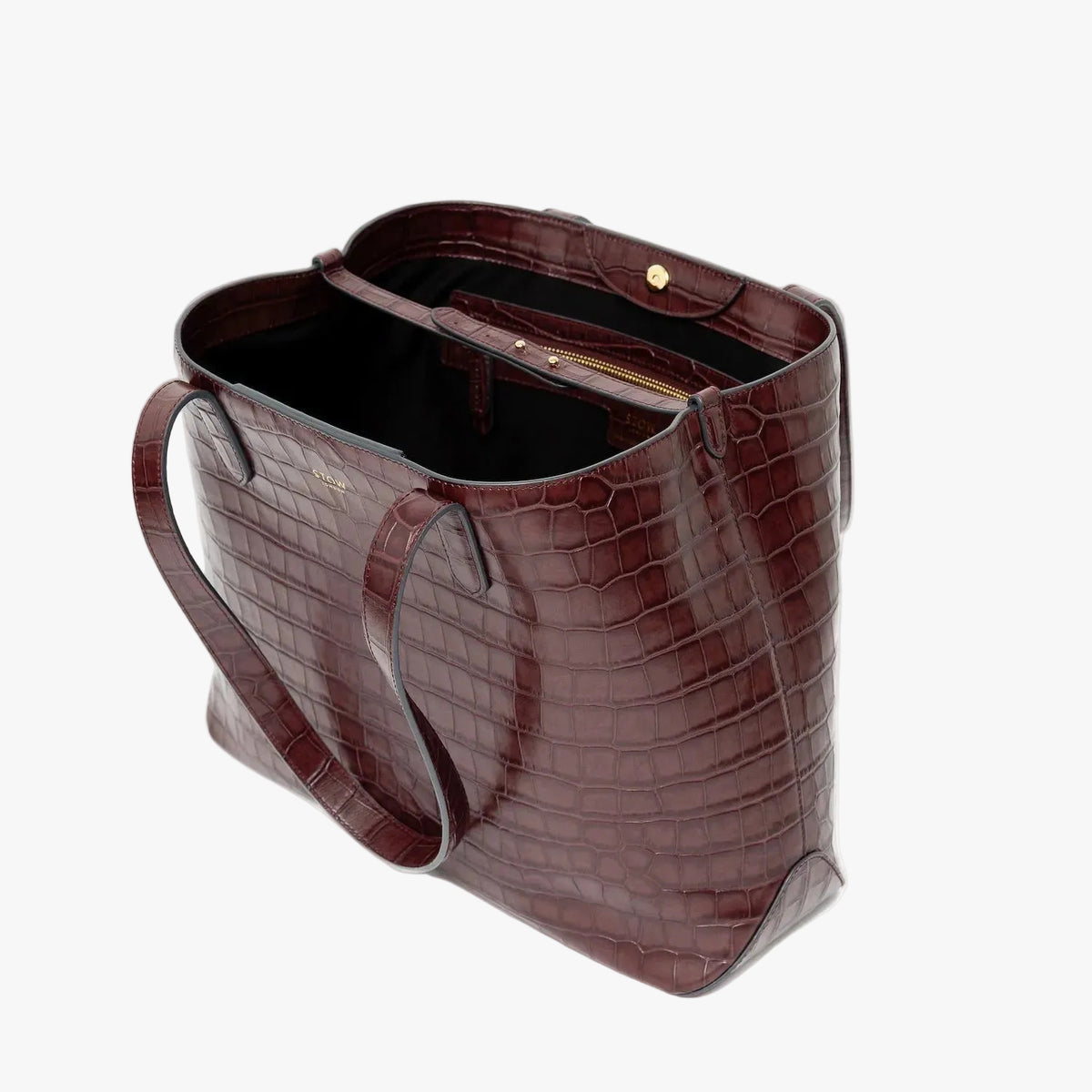 Stow London's Everyday Tote Bag in Burgundy Embossed Croc leather on a light grey background with magnets open showing black cotton interior, leather strap, magnetic closure and zip pocket featuring gold- coated stainless steel hardware