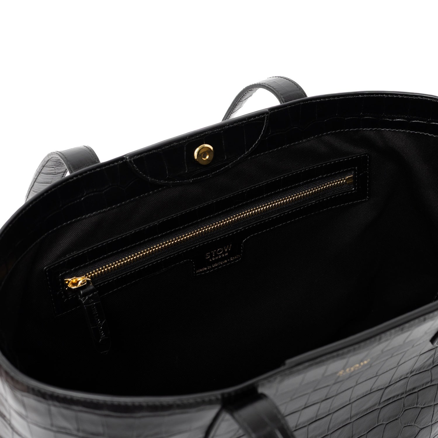 Close up of interior zip pocket and gold hardware on Black Embossed Croc Everyday Tote Bag shown on a white background
