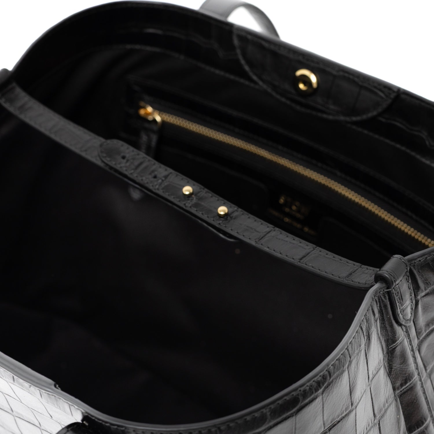 Close up of interior strap and gold hardware on Black Embossed Croc Everyday Tote Bag shown on a white background