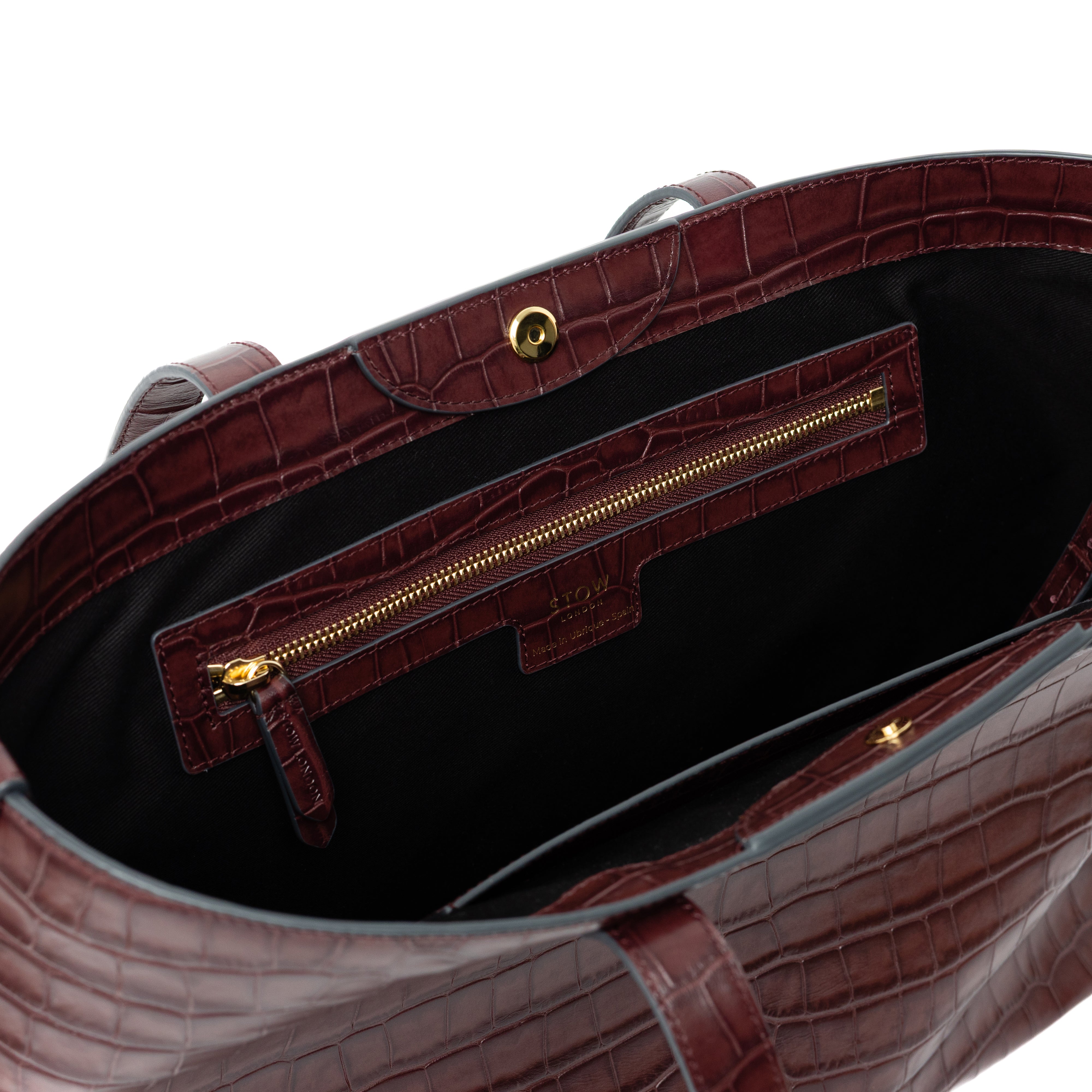 Close up of interior zip pocket and gold hardware on Burgundy Embossed Croc Everyday Tote Bag shown on a white background