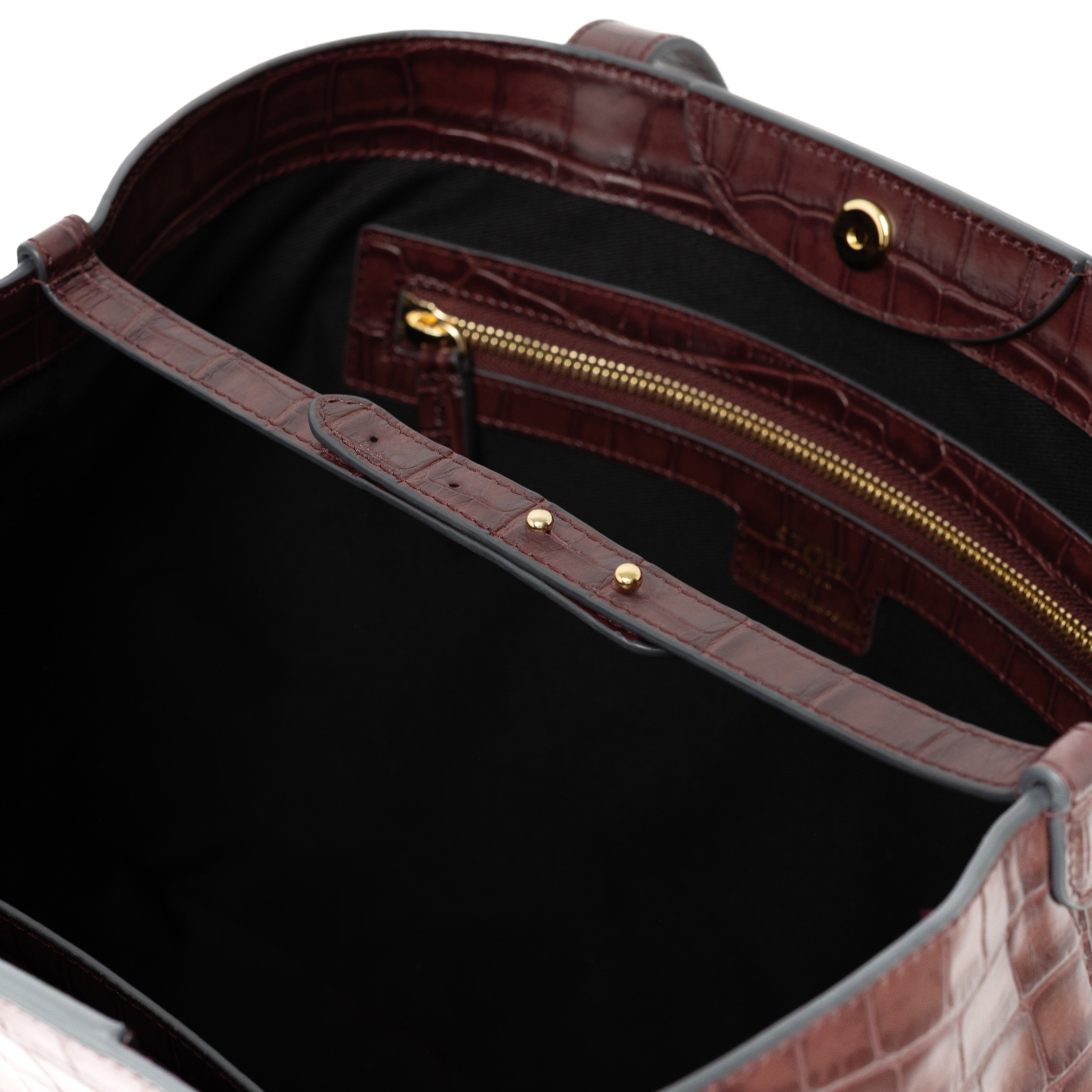 Close up of interior strap and gold hardware on Burgundy Embossed Croc Everyday Tote Bag shown on a white background