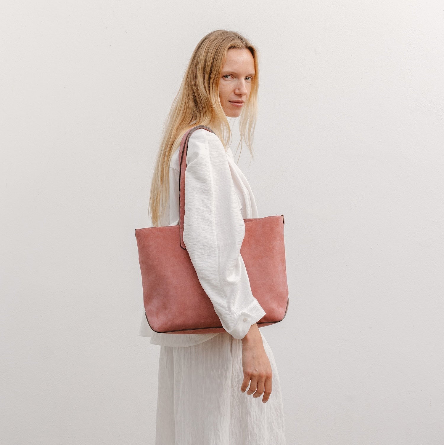Model wearing STOW London's Everyday Tote bag in Hazy Blush suede