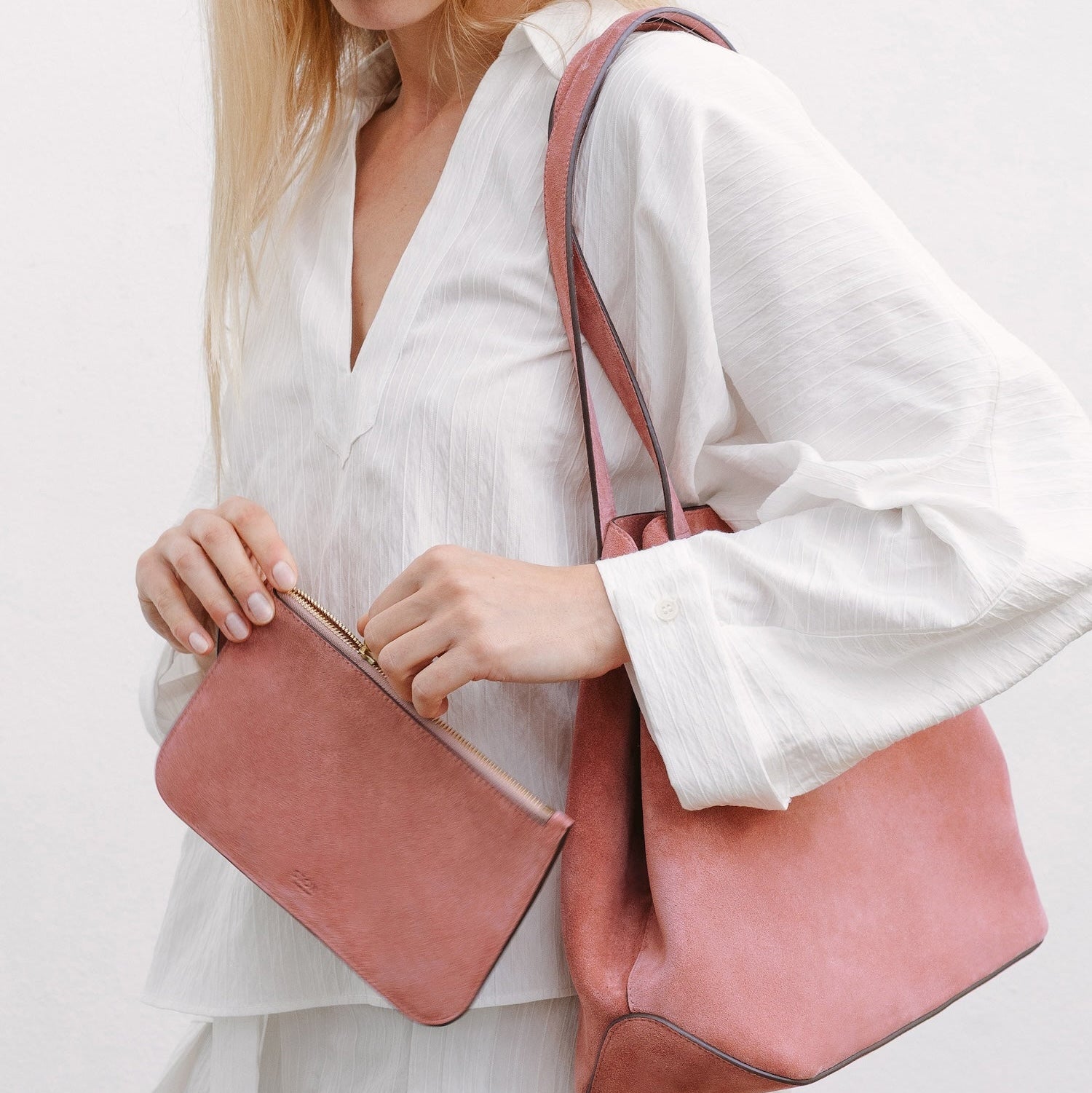 Model with STOW London's Everyday Tote bag in Hazy Blush suede and matching interior pouch featuring a small STOW London logo embossed on the front panel