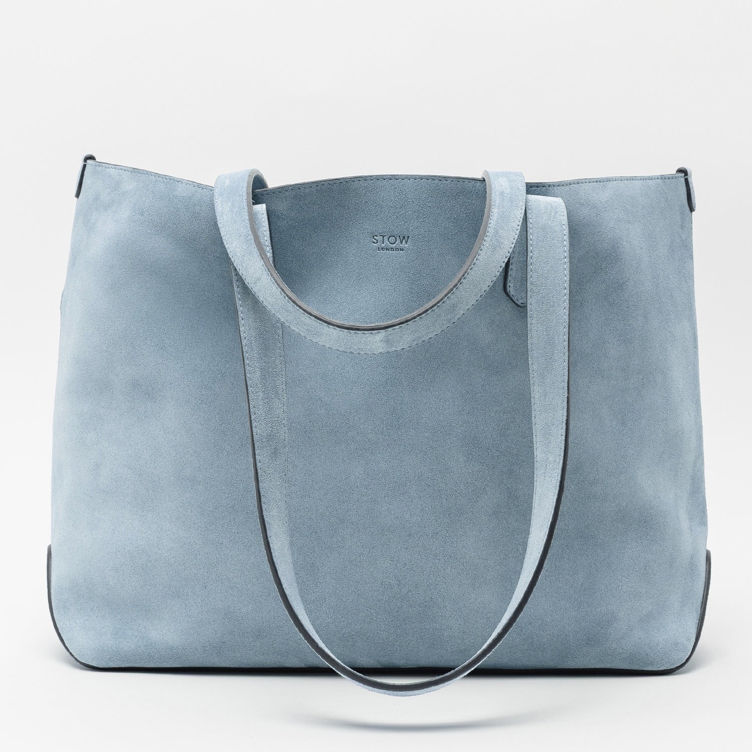 STOW London's Everyday Tote bag in Misty Blue suede on a light grey background featuring a small STOW London logo embossed on the front panel