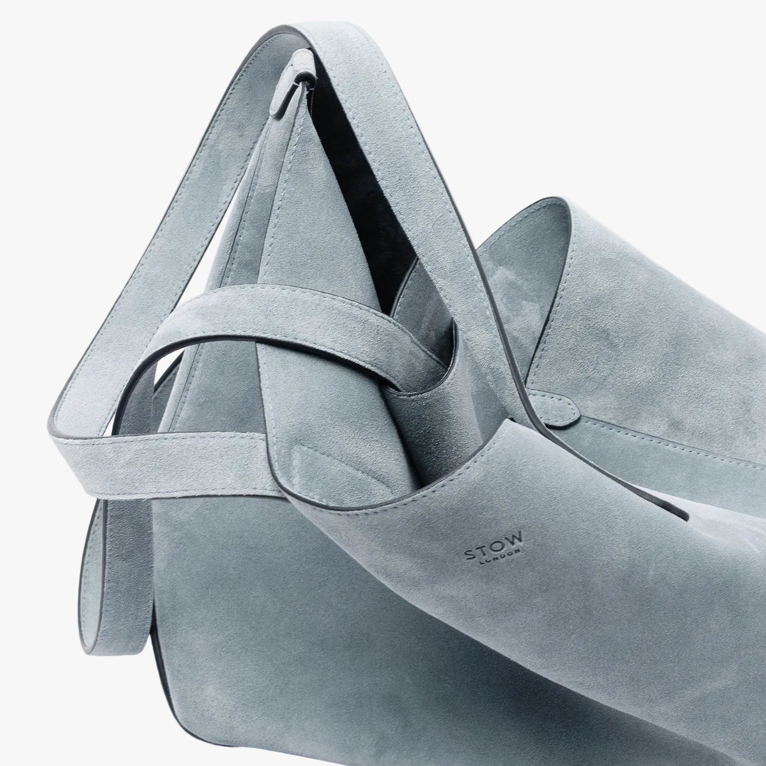 STOW London's Everyday Tote bag in Misty Blue suede on a light grey background featuring a small STOW London logo embossed on the front panel