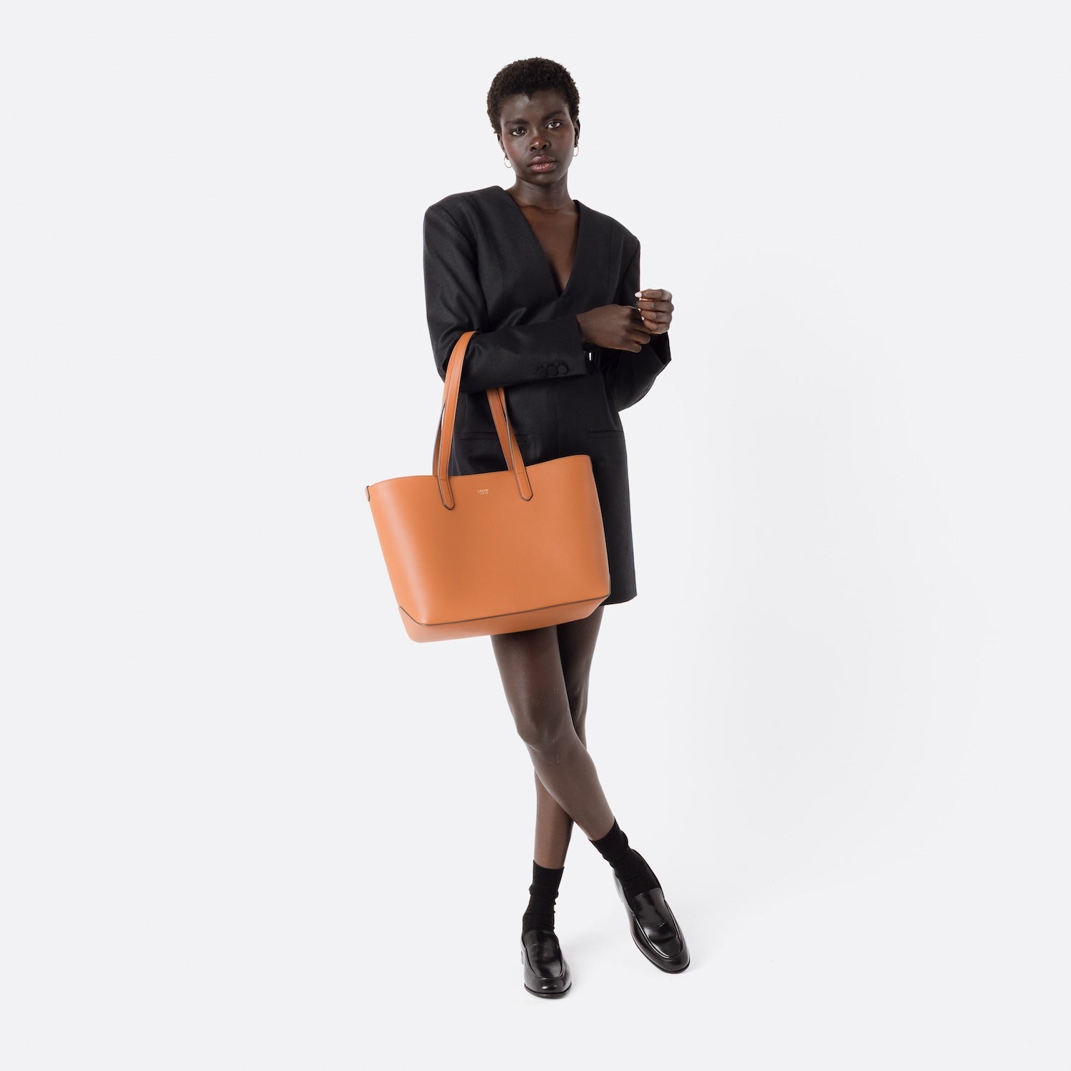 STOW London's Everyday Tote bag in Earth Tan smooth leather on model's arm on a white background