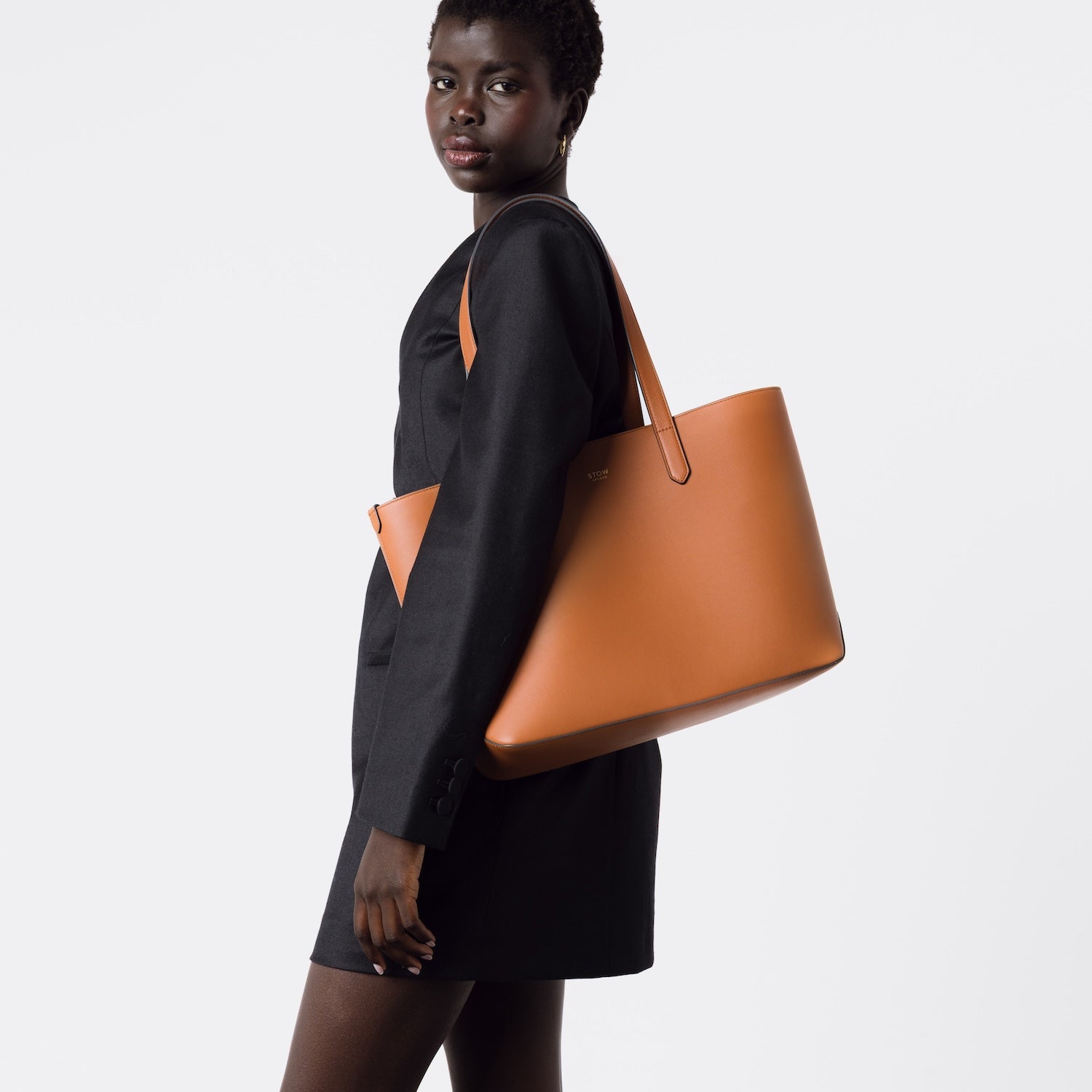 STOW London's Everyday Tote bag in Earth Tan smooth leather worn on model's shoulder on a white background