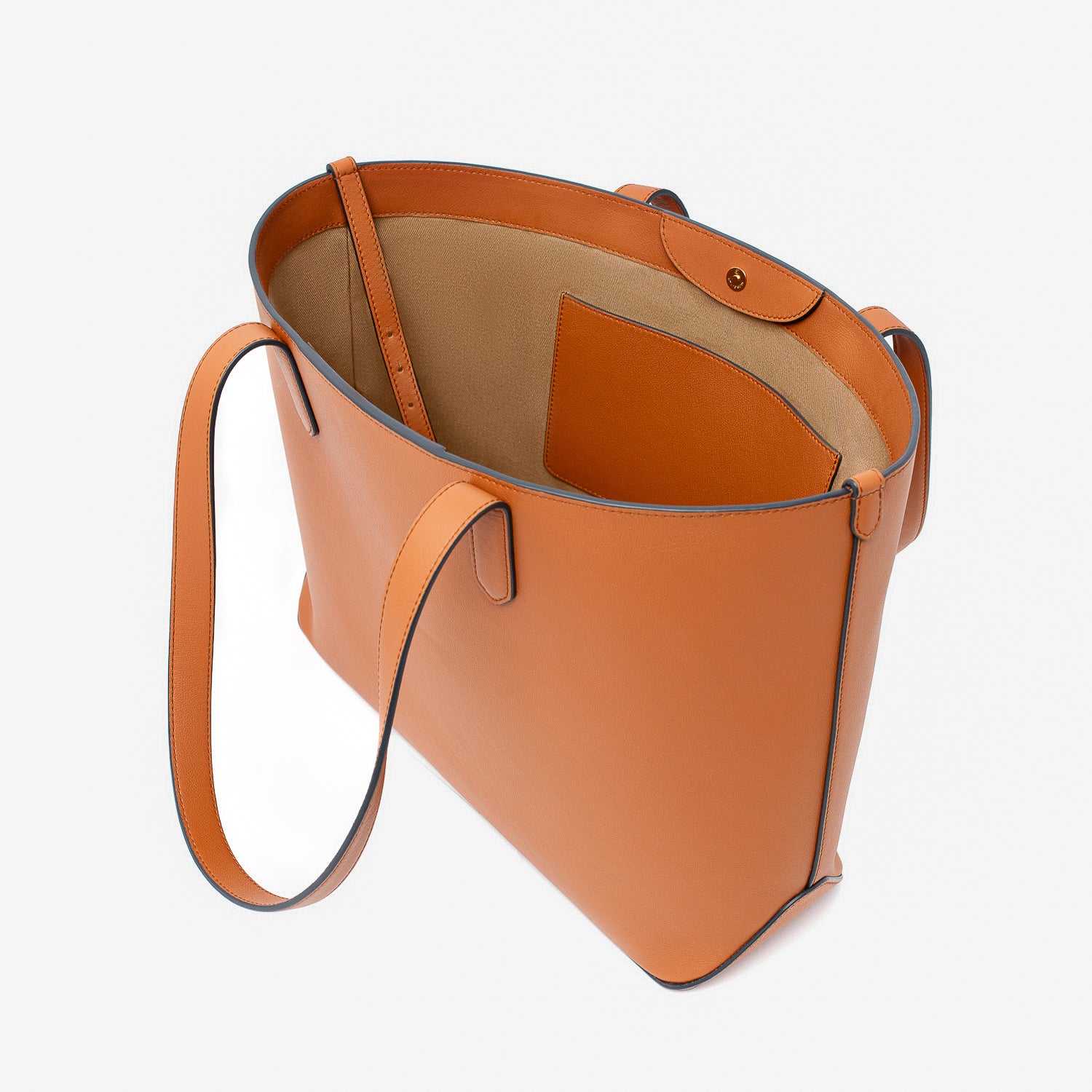 Stow London's Everyday Tote Bag in Earth Tan smooth leather with magnets open showing cotton interior, leather strap and slip pocket on a light grey background