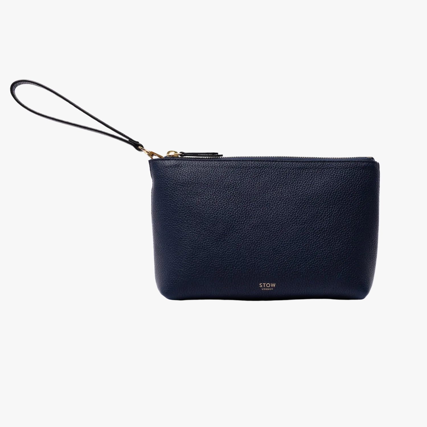 STOW London's travel pouch in Navy pebbled leather on a light grey background featuring its detachable wrist strap, a YKK zip and a fine gold embossed logo on the front bottom