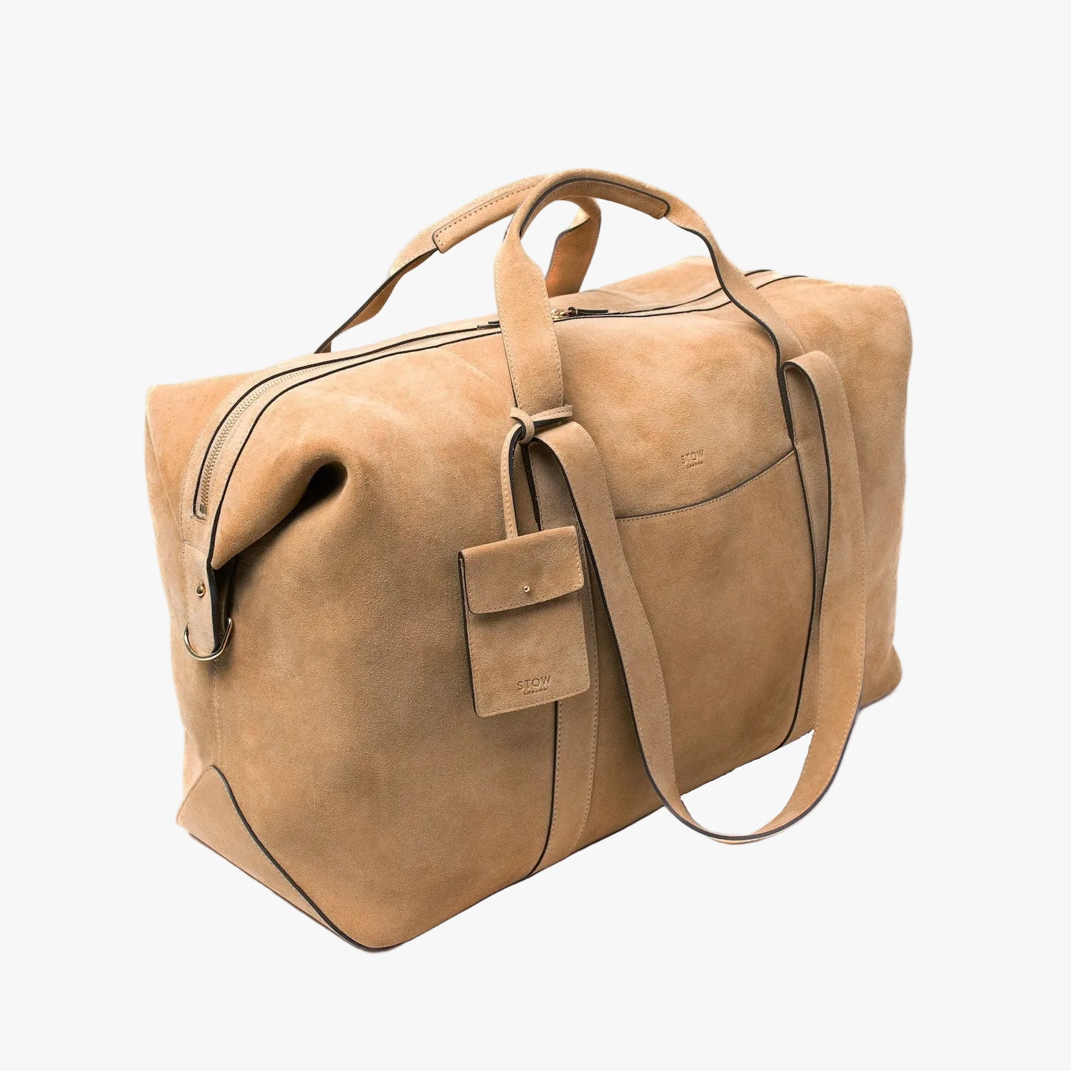 Off-axis view of STOW London's Weekend bag in Soft Sand suede on a light grey background