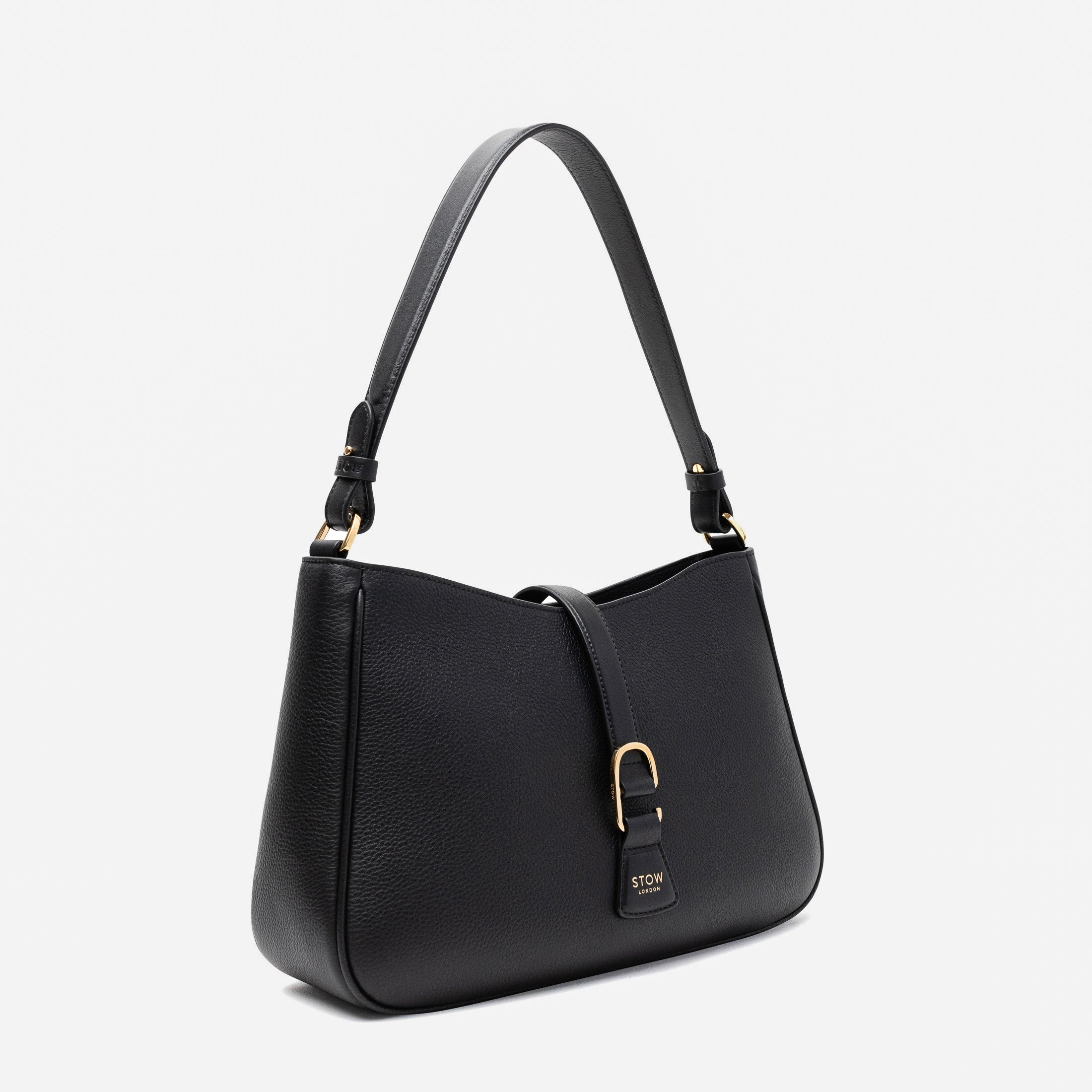 Off-axis view of STOW London's Beth bag in Black pebbled and smooth leather featuring gold-coated stainless steel hardware and clip on a white background