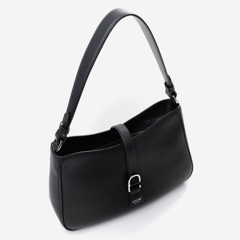 Top angled view of STOW London's Beth bag in Black pebbled and smooth leather with zipper open showing the interior cotton lining and card holder pocket, featuring silver stainless steel hardware on a white background