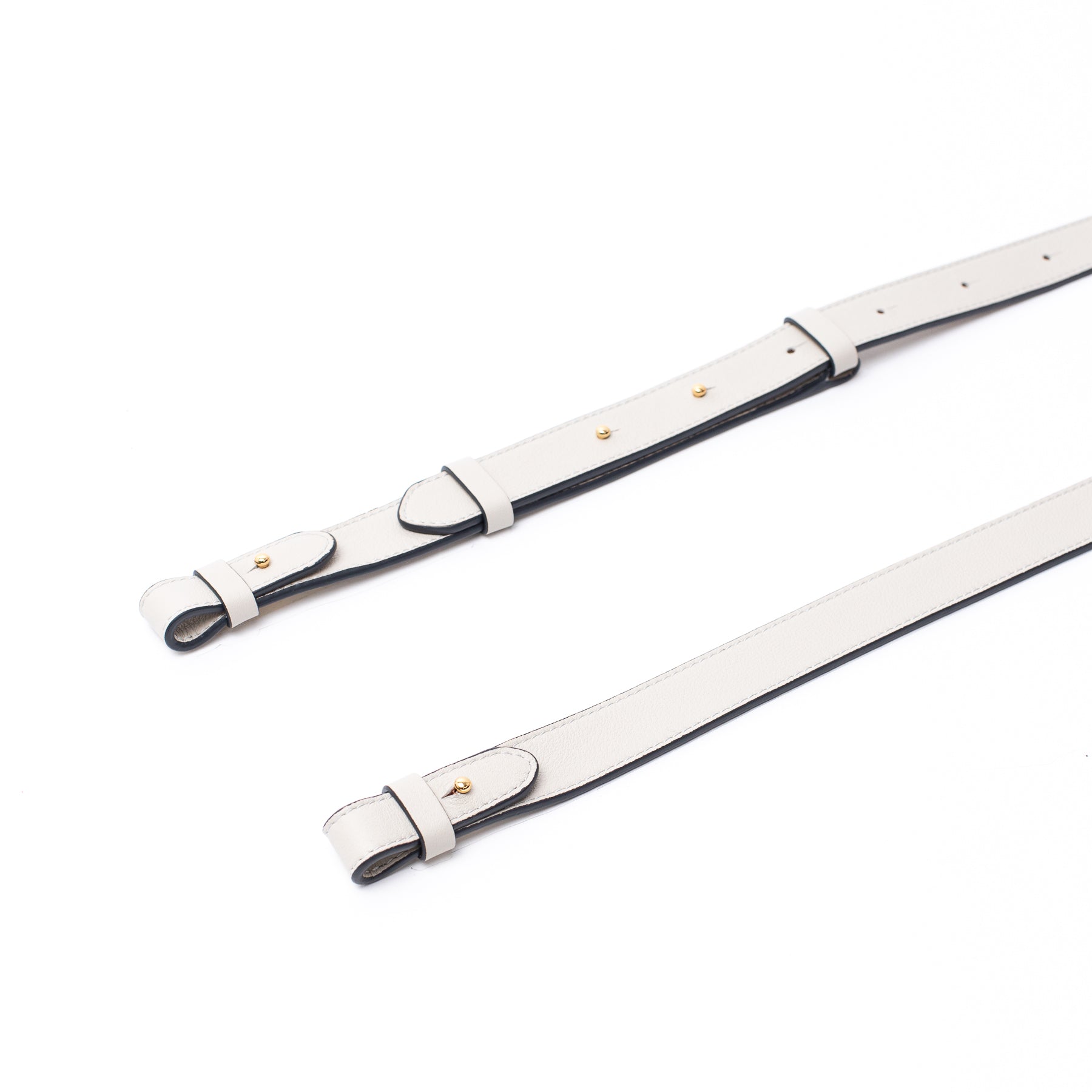 Close up shot of STOW London's detachable crossbody strap for the Beth bag in Cloud Grey leather featuring Gold stainless steel hardware on a white background