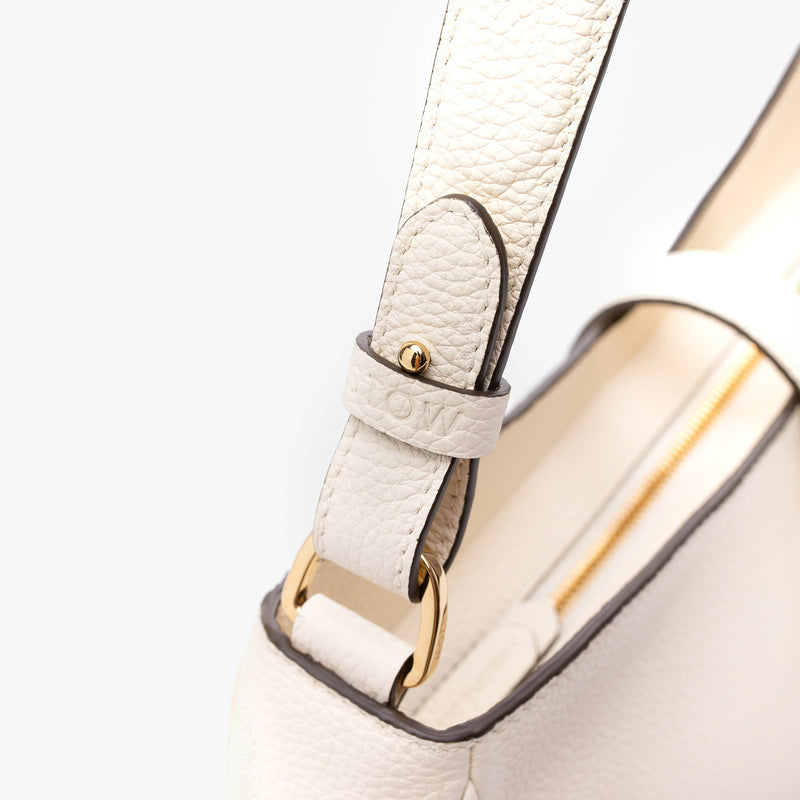 Close up shot of STOW London's Beth bag in Spring Moon pebbled and smooth leather featuring the detachable strap and gold-coated, stainless steel hardware on a white background