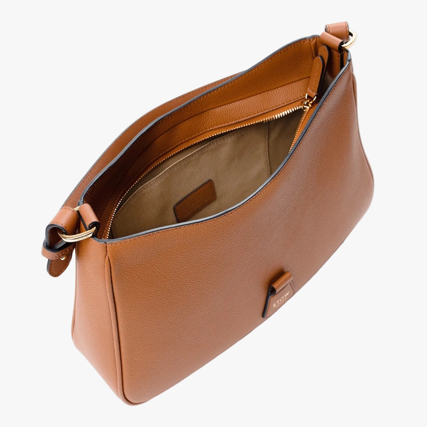 Overhead shot of STOW London's Beth Shoulder bag in Earth Tan pebbled leather with zipper open showing cotton lining and slip pocket featuring gold-coated stainless steel hardware on a light grey background