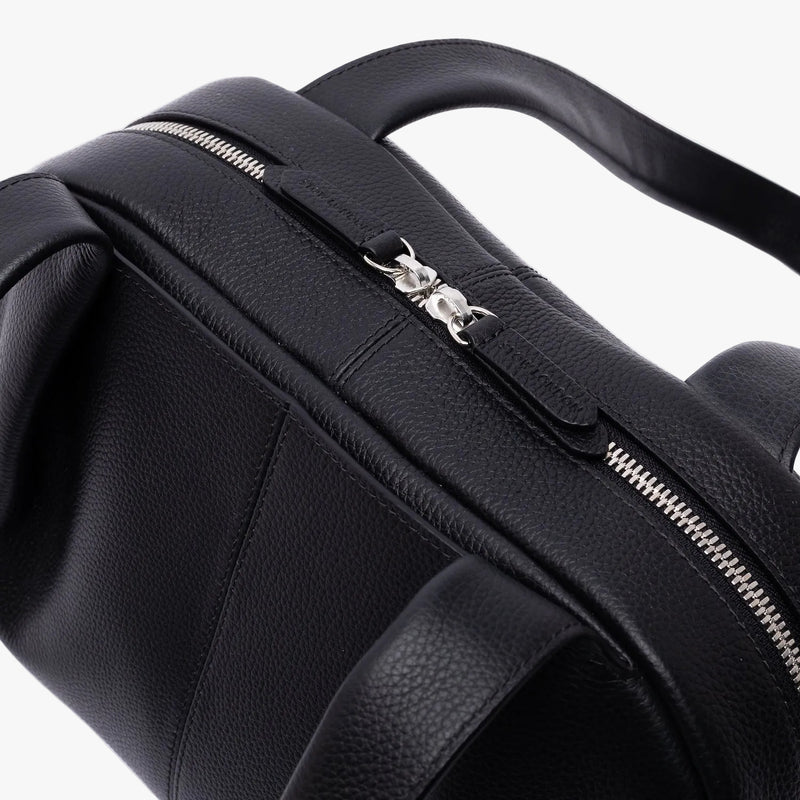 Close up of the silver zip top closure on STOW London's Bowling bag in Black pebbled leather on a light grey background