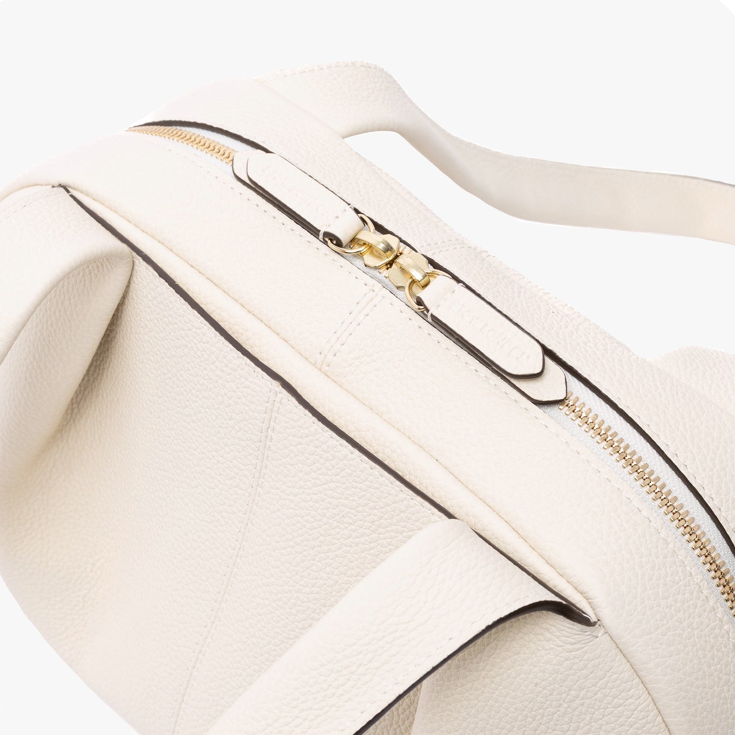 Close up of STOW London's Bowling bag in Spring Moon pebbled leather featuring the pleated front panel and gold zip closure on a light grey background