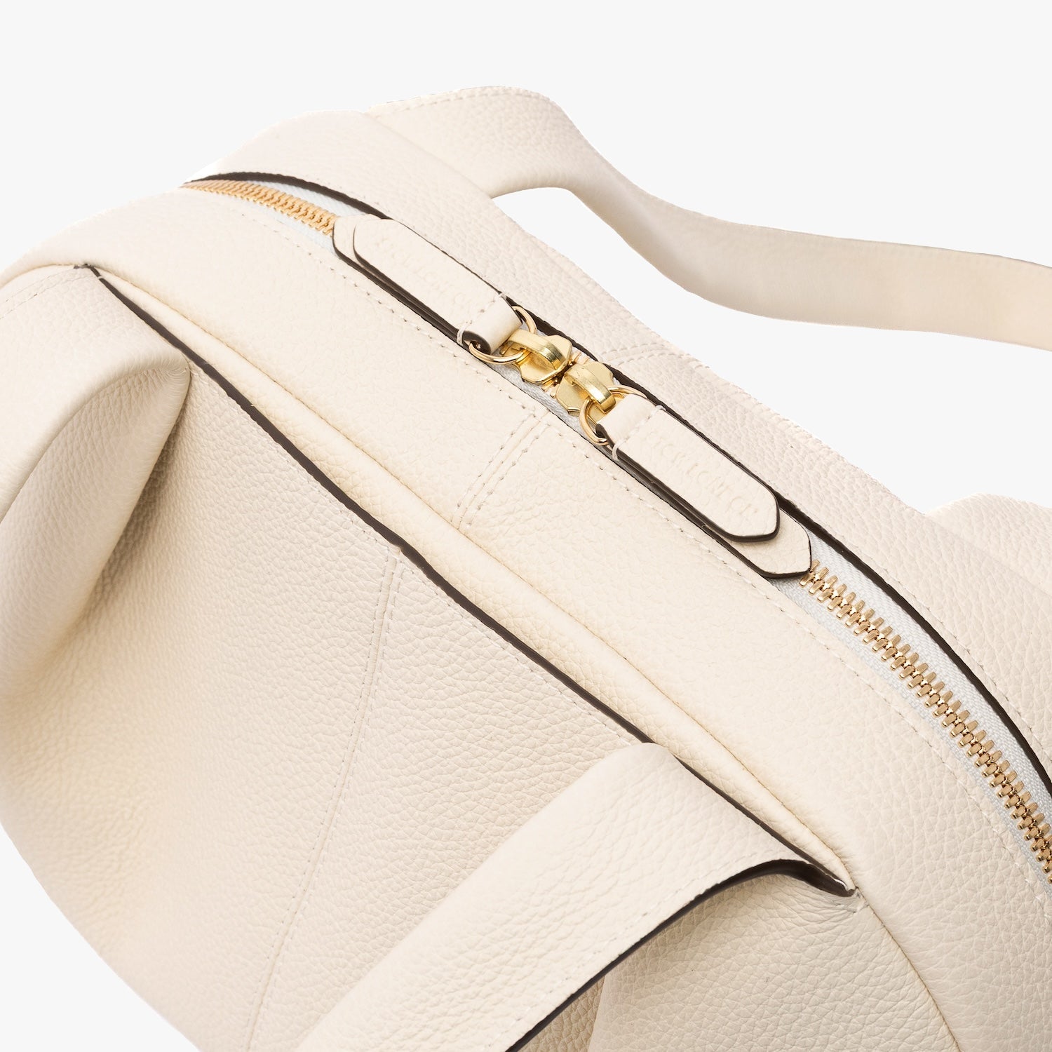 Close up of STOW London's Bowling bag in Spring Moon pebbled leather featuring the pleated front panel and the gold zip closure on a light grey background