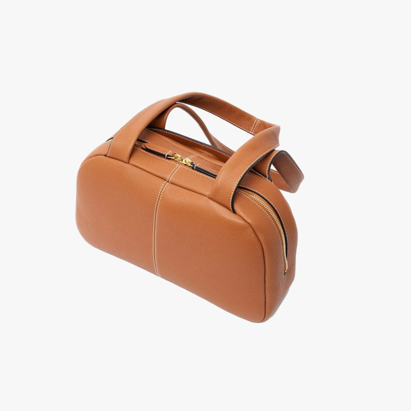 Back panel of STOW London's Bowling bag in Earth Tan pebbled leather on a light grey background