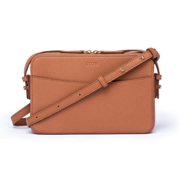 Earth Tan leather Camera Bag by STOW, studio image showing front of bag and crossbody strap.