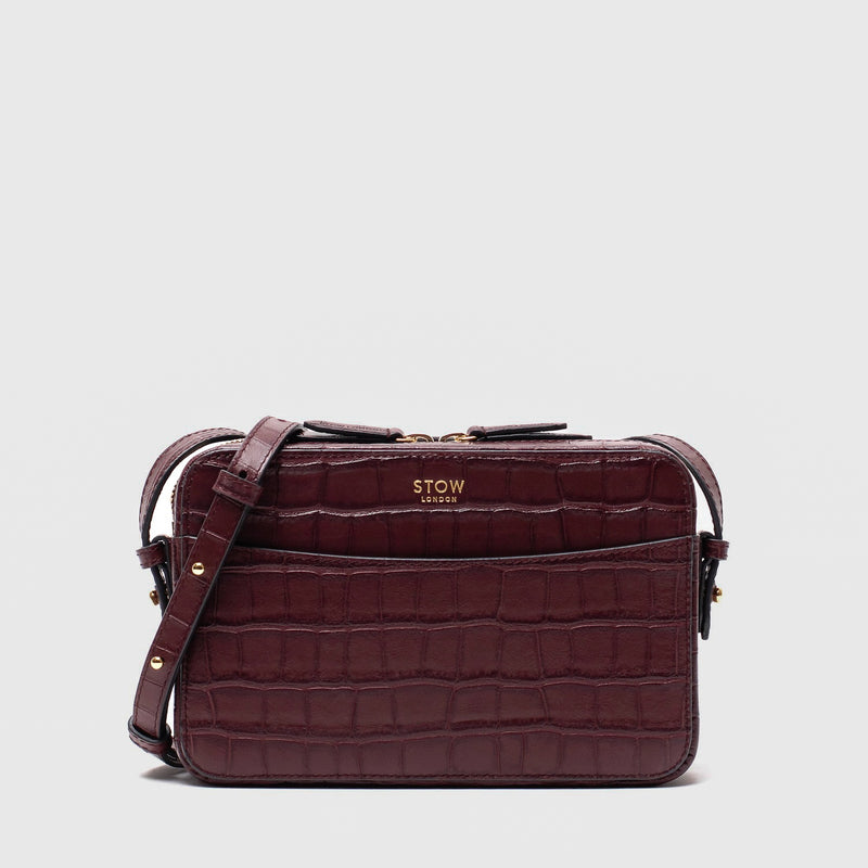 STOW London's Camera bag in Burgundy Embossed Croc leather with detachable crossbody strap featuring gold-coated stainless steel hardware on a white background