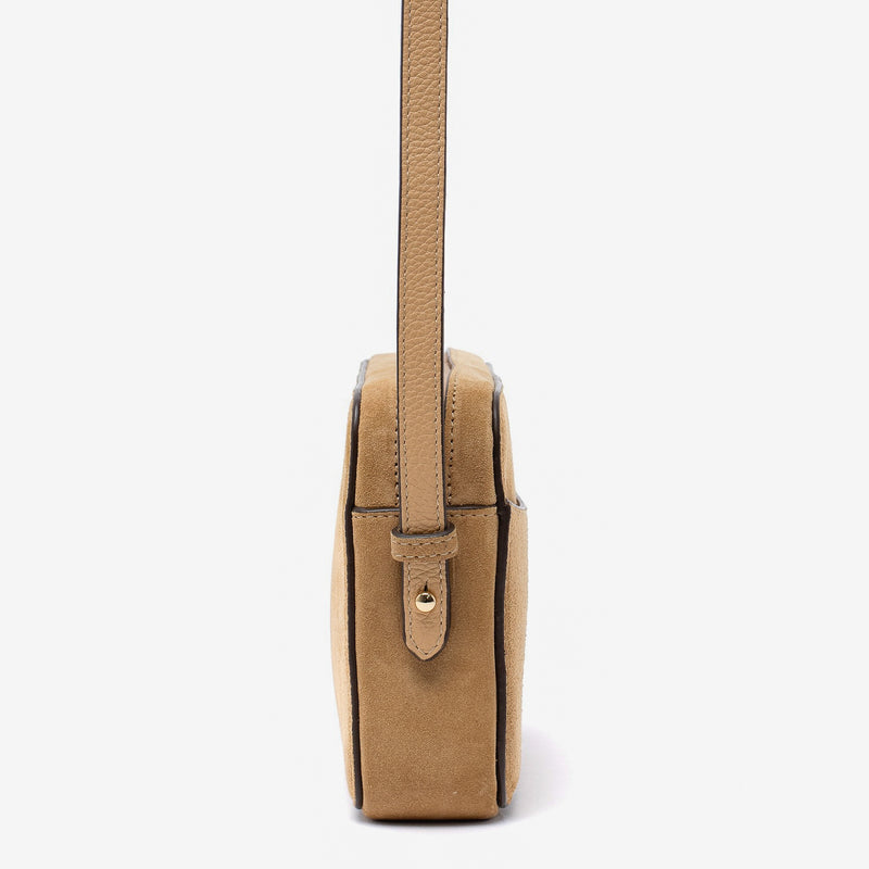 Side view of STOW London's Camera bag in Soft Sand Suede leather featuring gold-coated stainless steel hardware on a white background