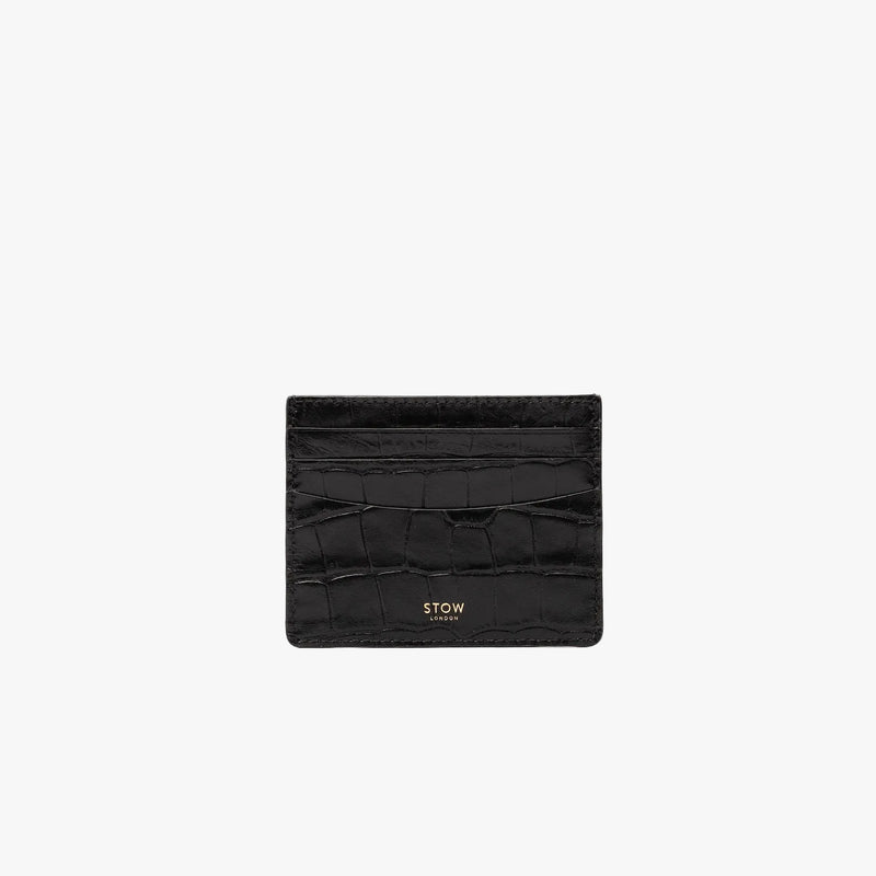 STOW London's Cardholder in Black Embossed Croc leather on a light grey background featuring a fine gold embossed logo on the front bottom. 